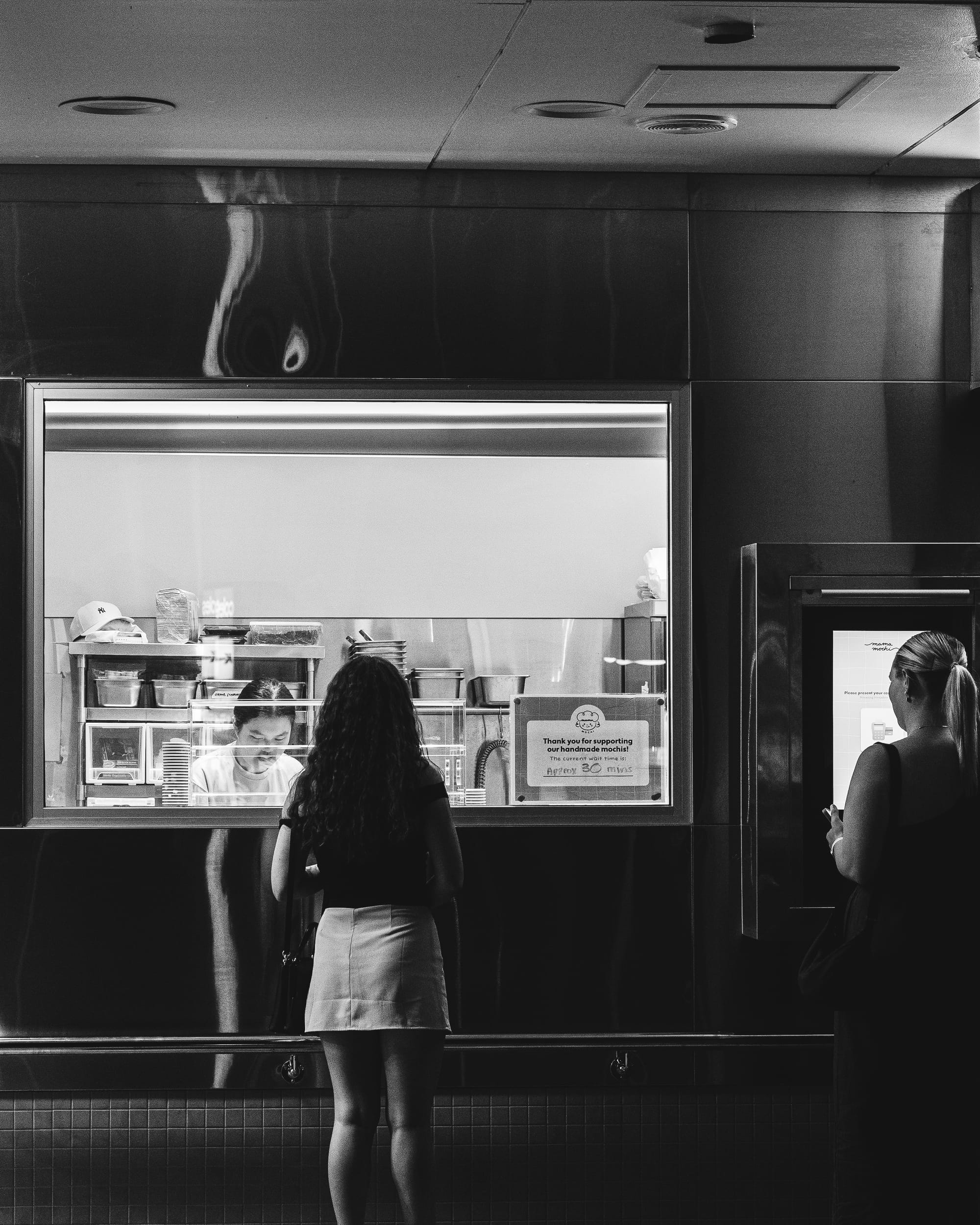 Female standing in-front of window that overlooks a small kitchen