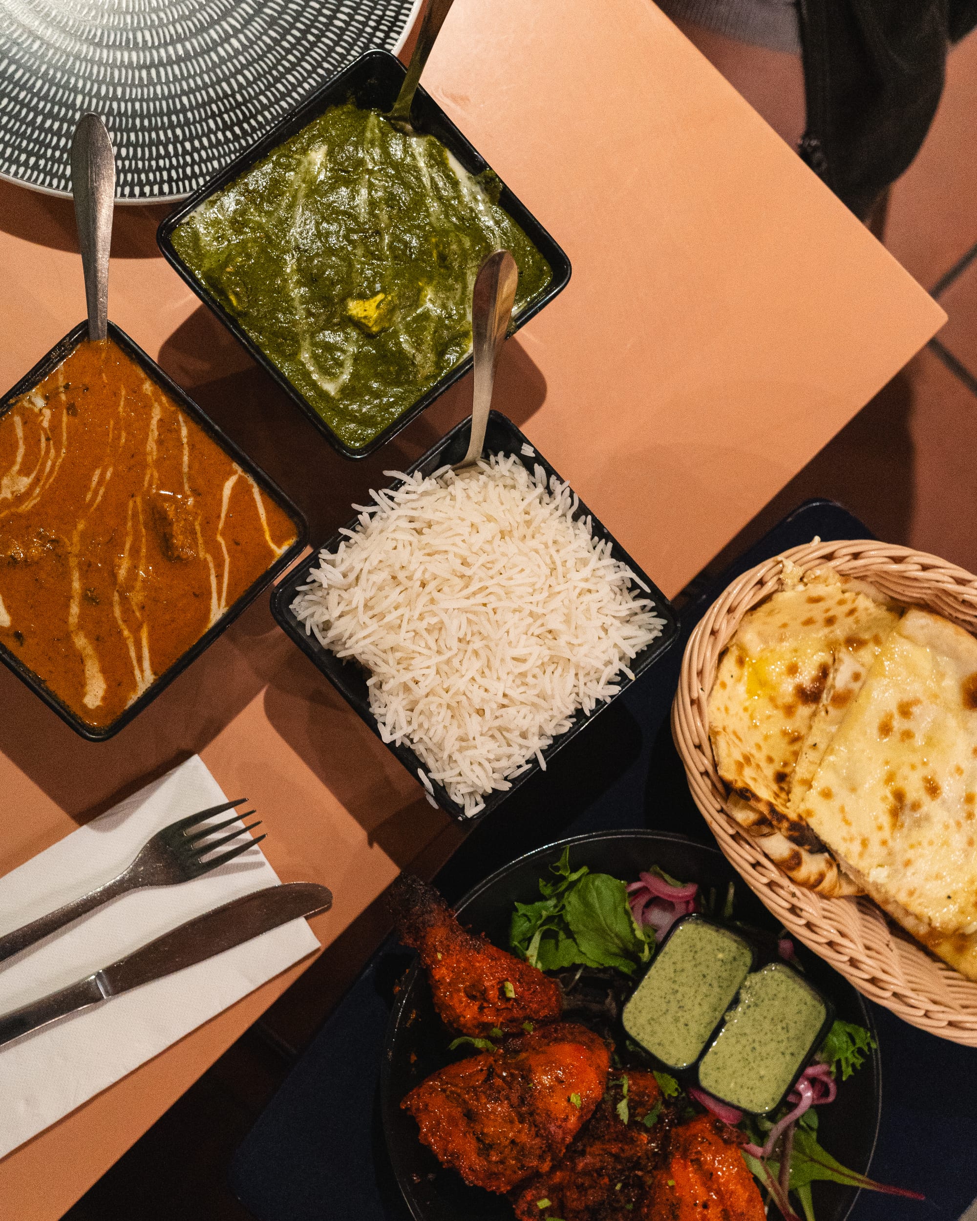 Top down shot of curries, basmati rice, naan and tandoori chicken