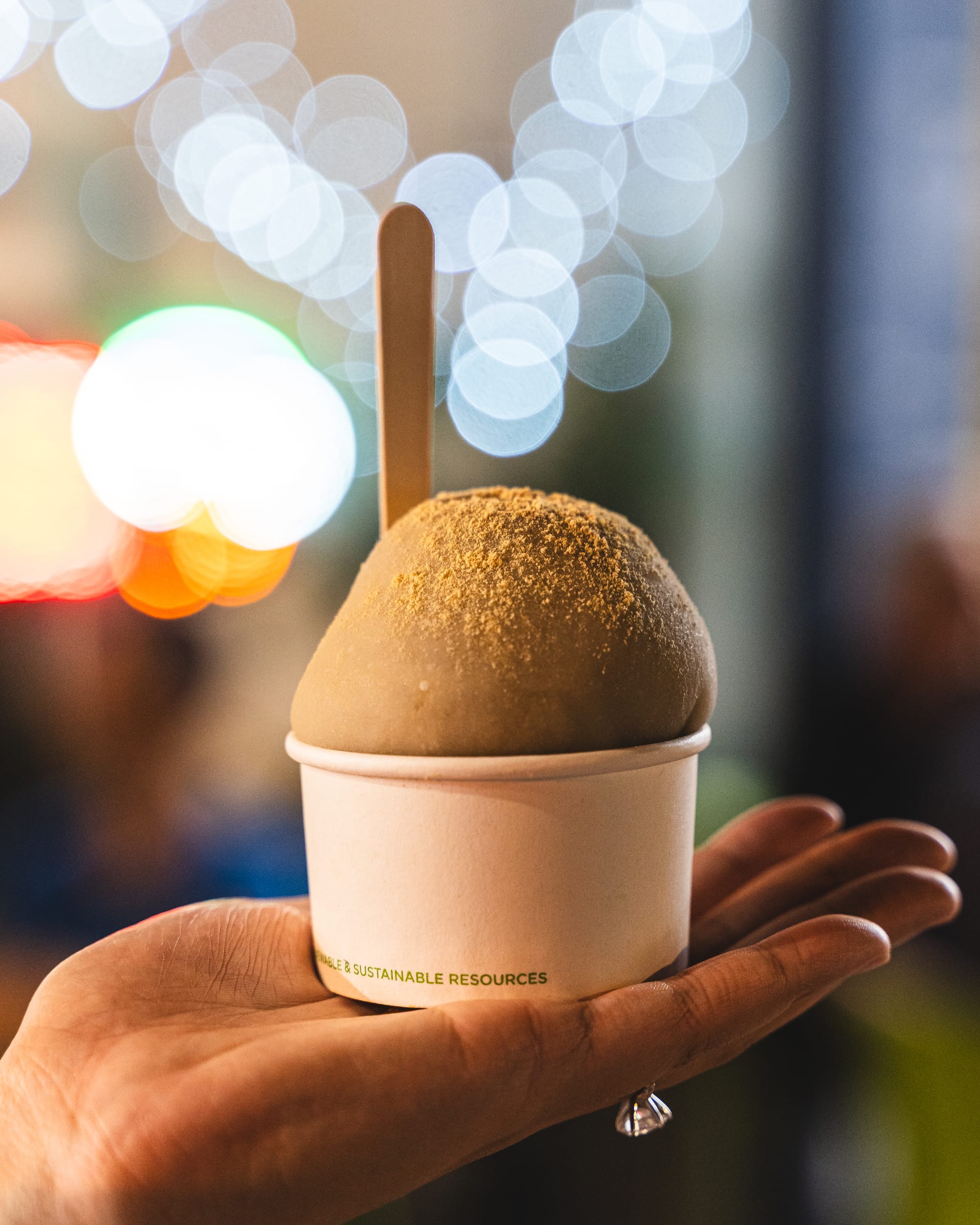 Hand holding ice-cream mochi in a cup