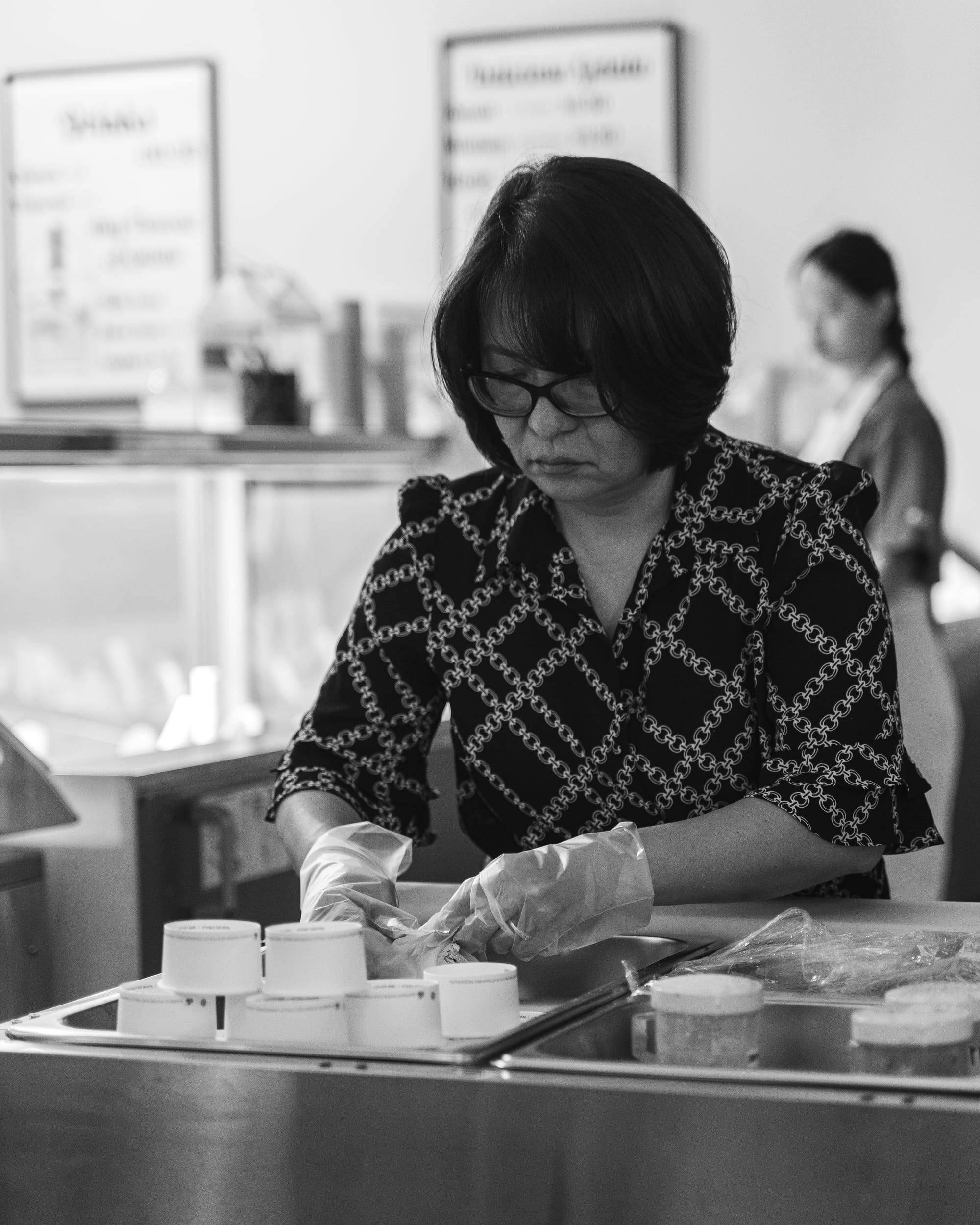 Black and white photo of lady wrapping ice-cream mochii