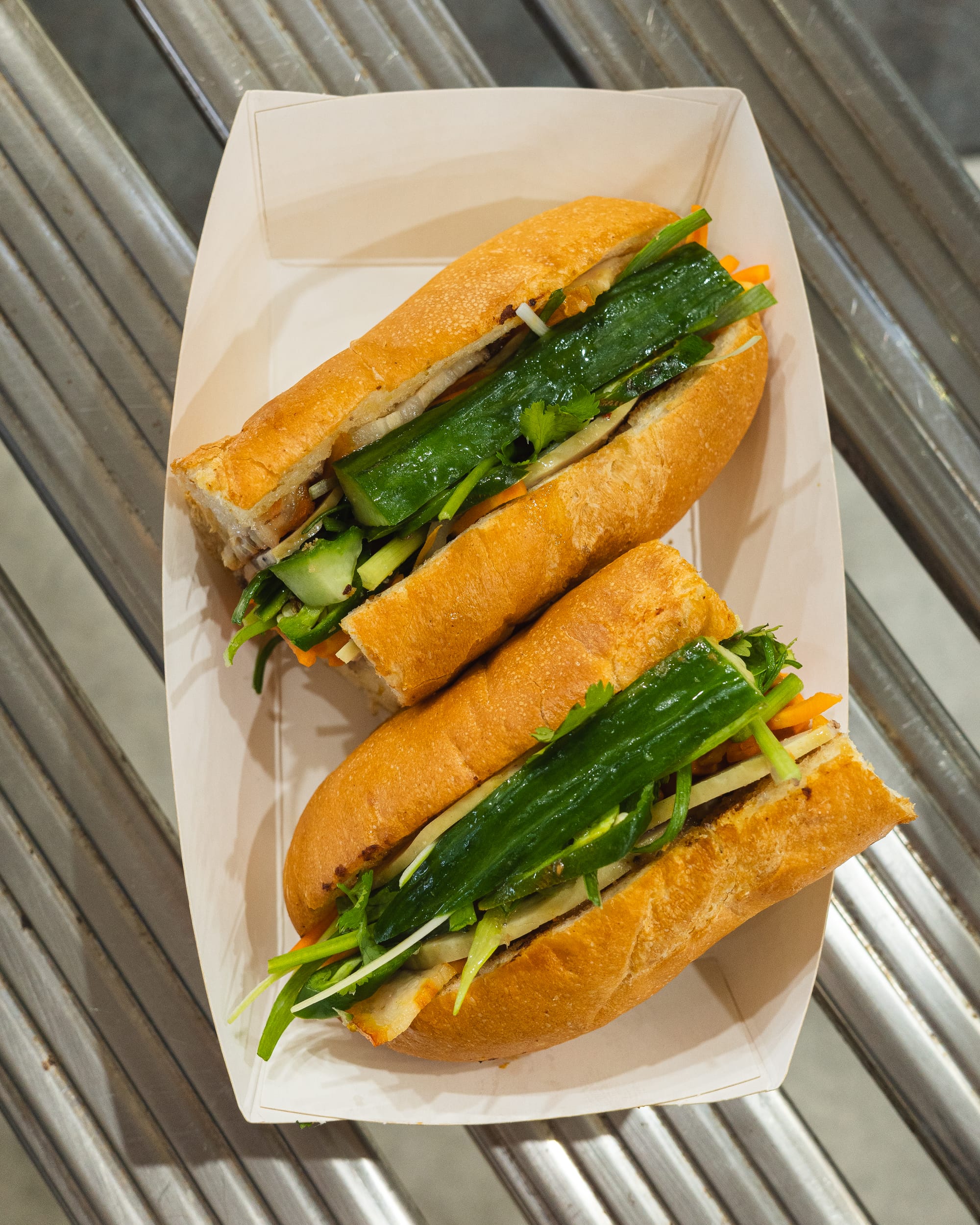 Top down shot of baguette with cucumber and shredded carrots showing