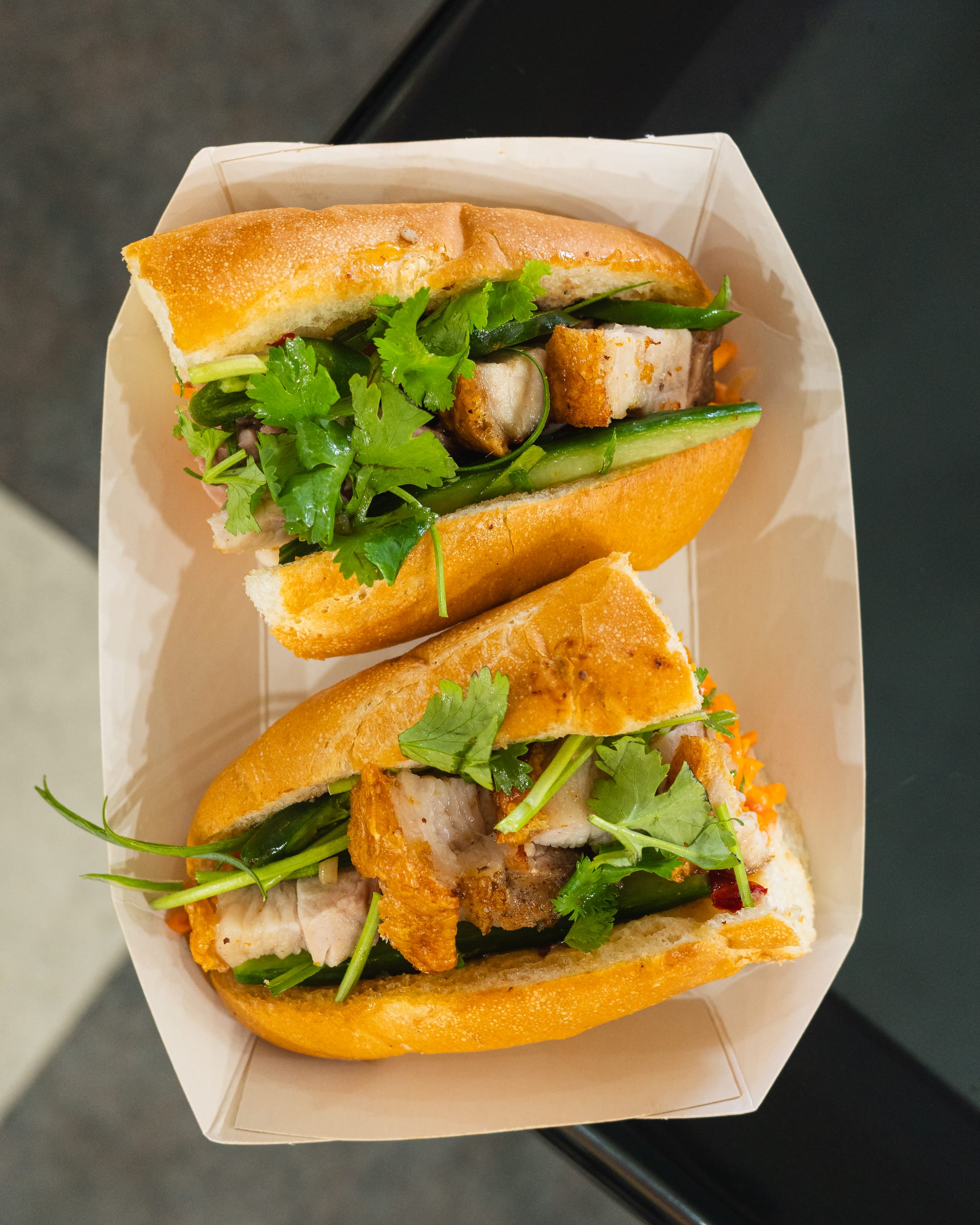 Top down shot of baguette with roast pork and coriander