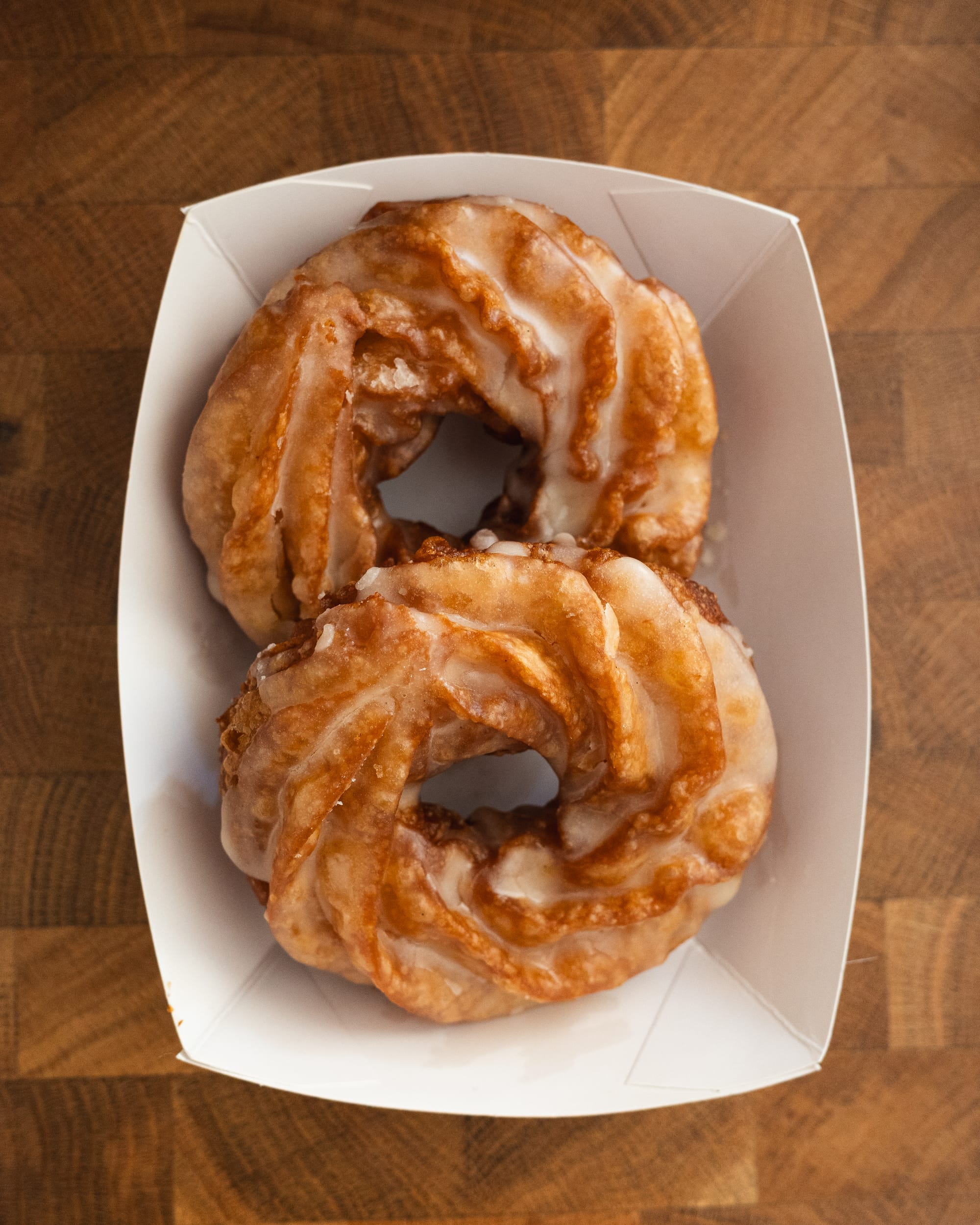 Top down photo of cruller donuts in cardboard tray