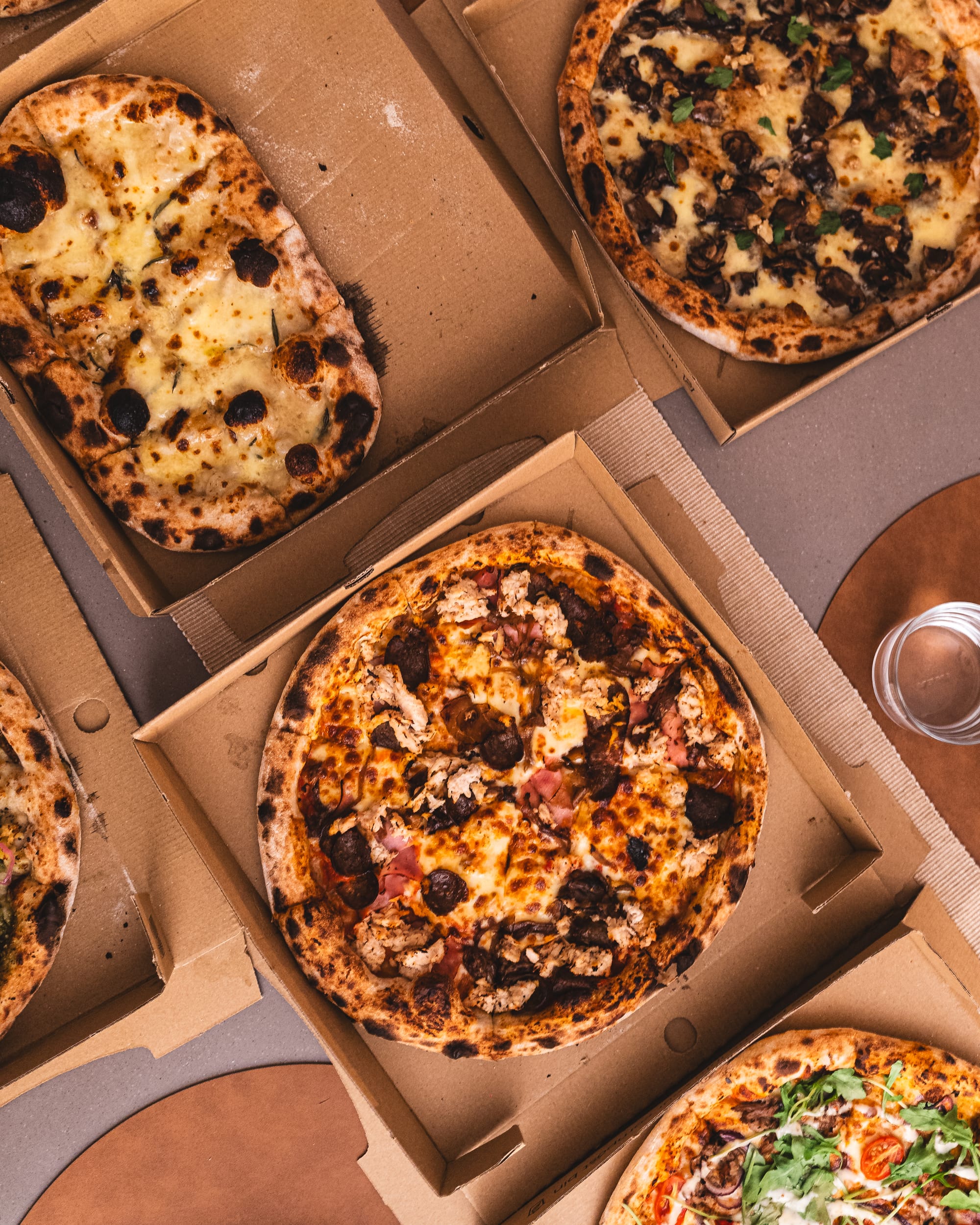 Top down shot of pizzas in cardboard trays