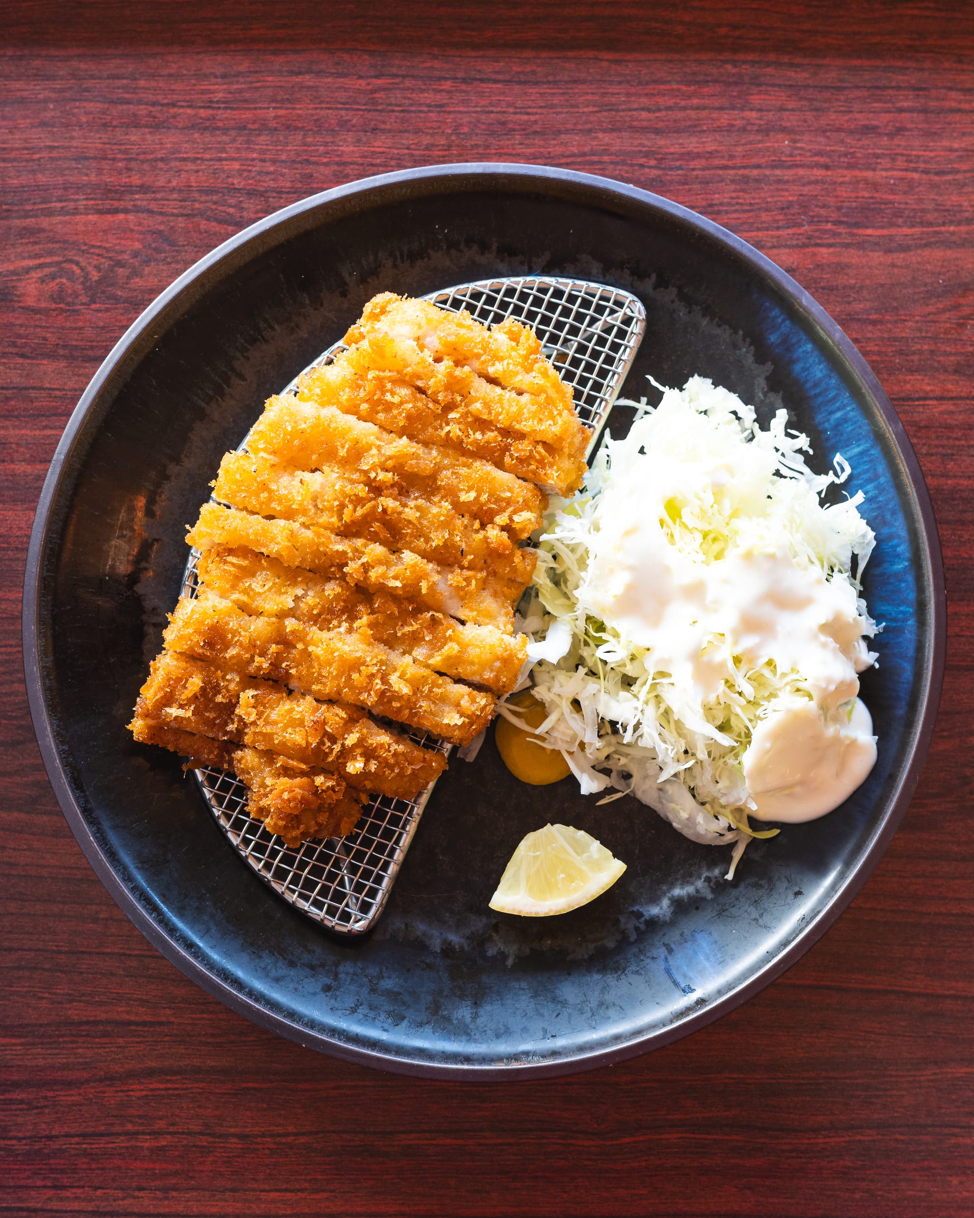Top down shot of pork katsu on a plate with cabbage salad on the side