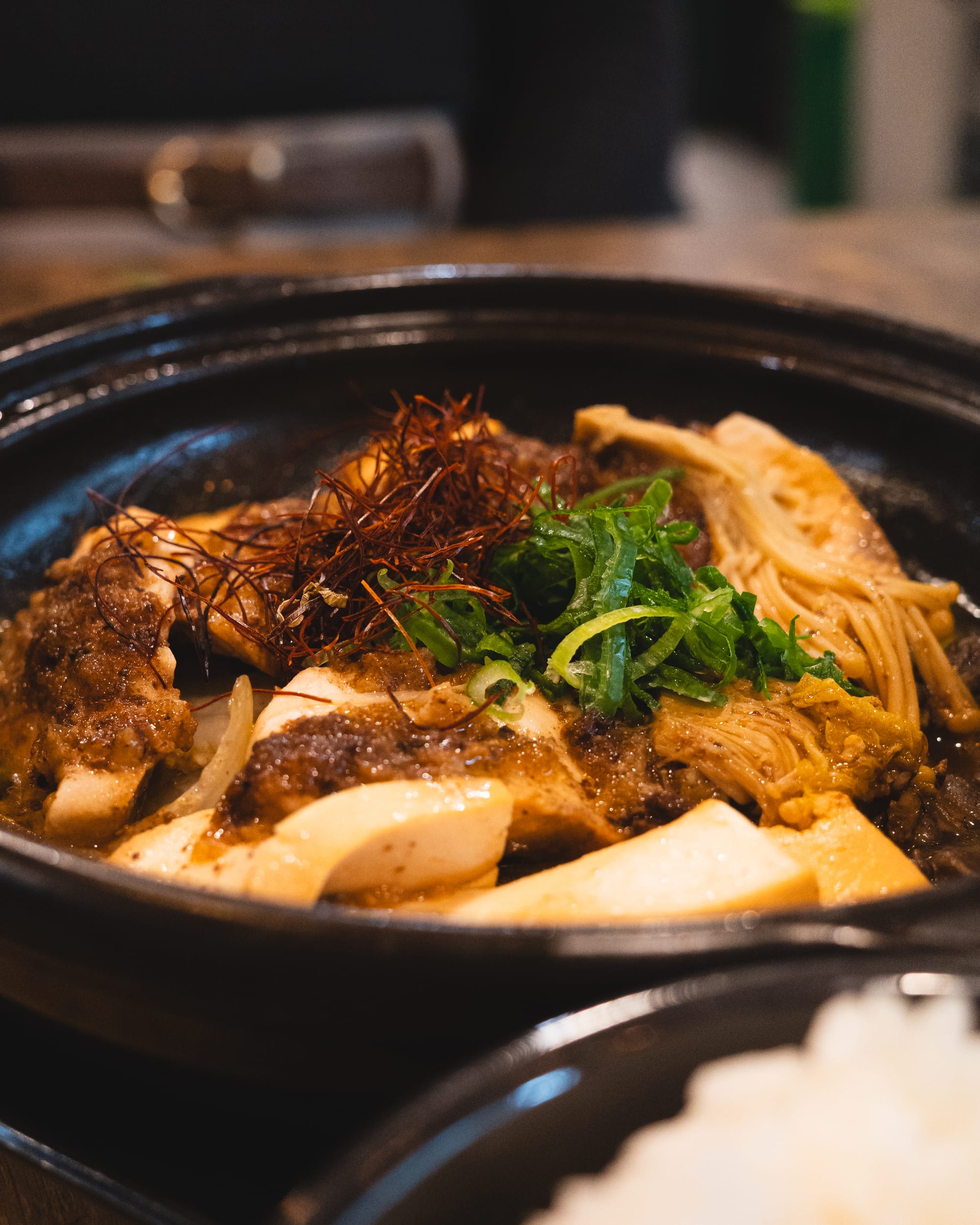 Close up of braised fish with mushrooms and tofu in a claypot