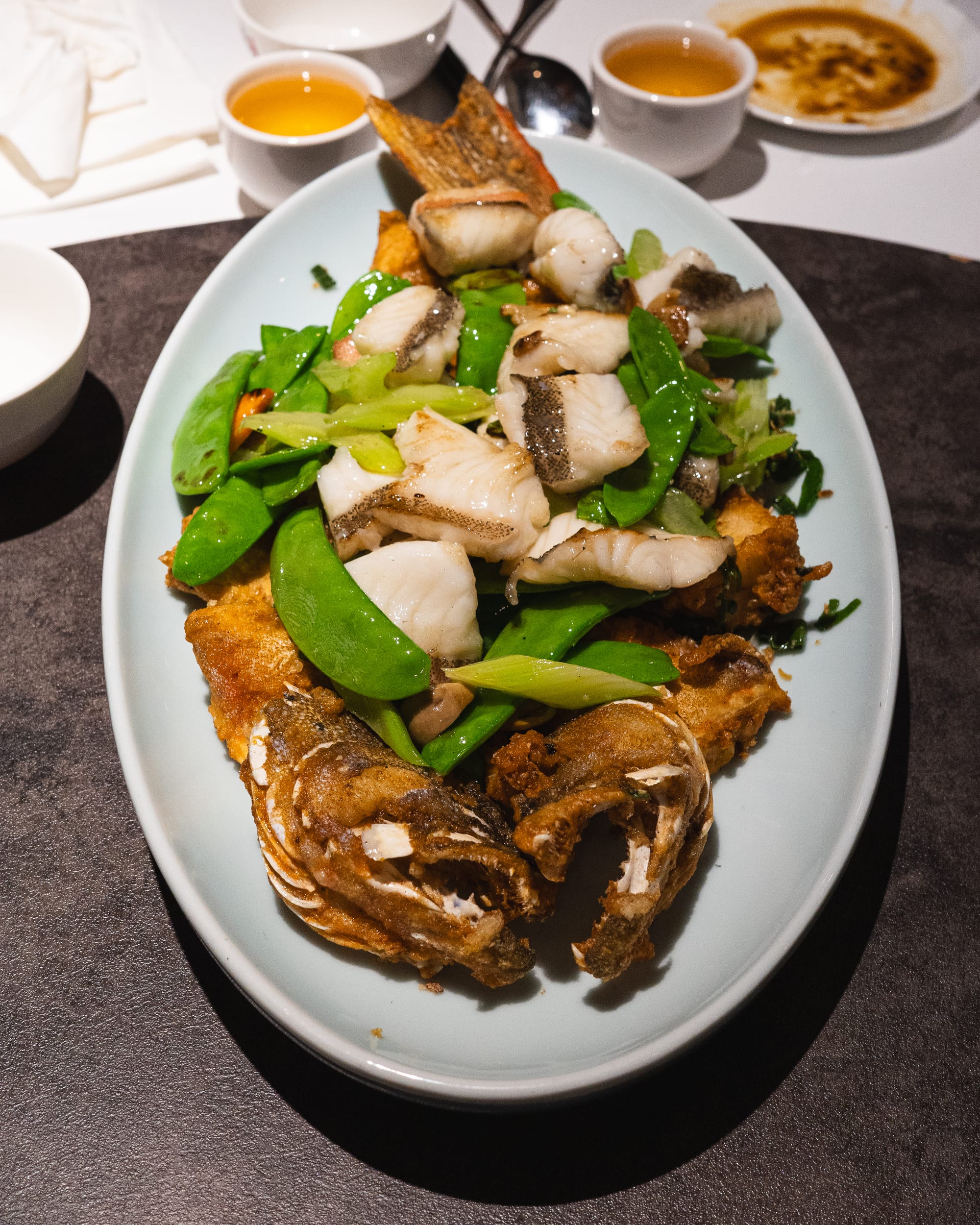 Close up of whole fish cooked two ways with vegetables