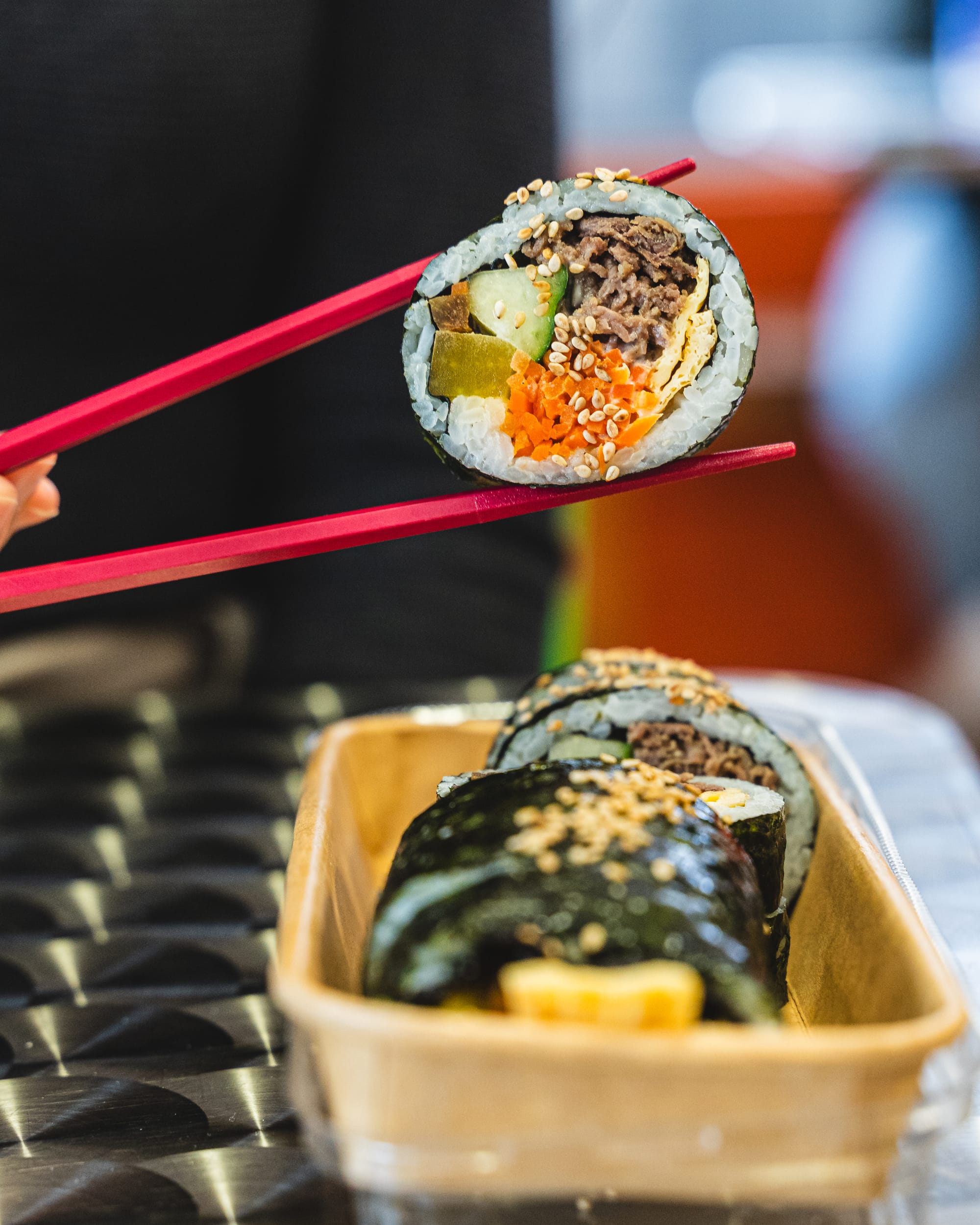Close up of chopsticks holding a maki roll