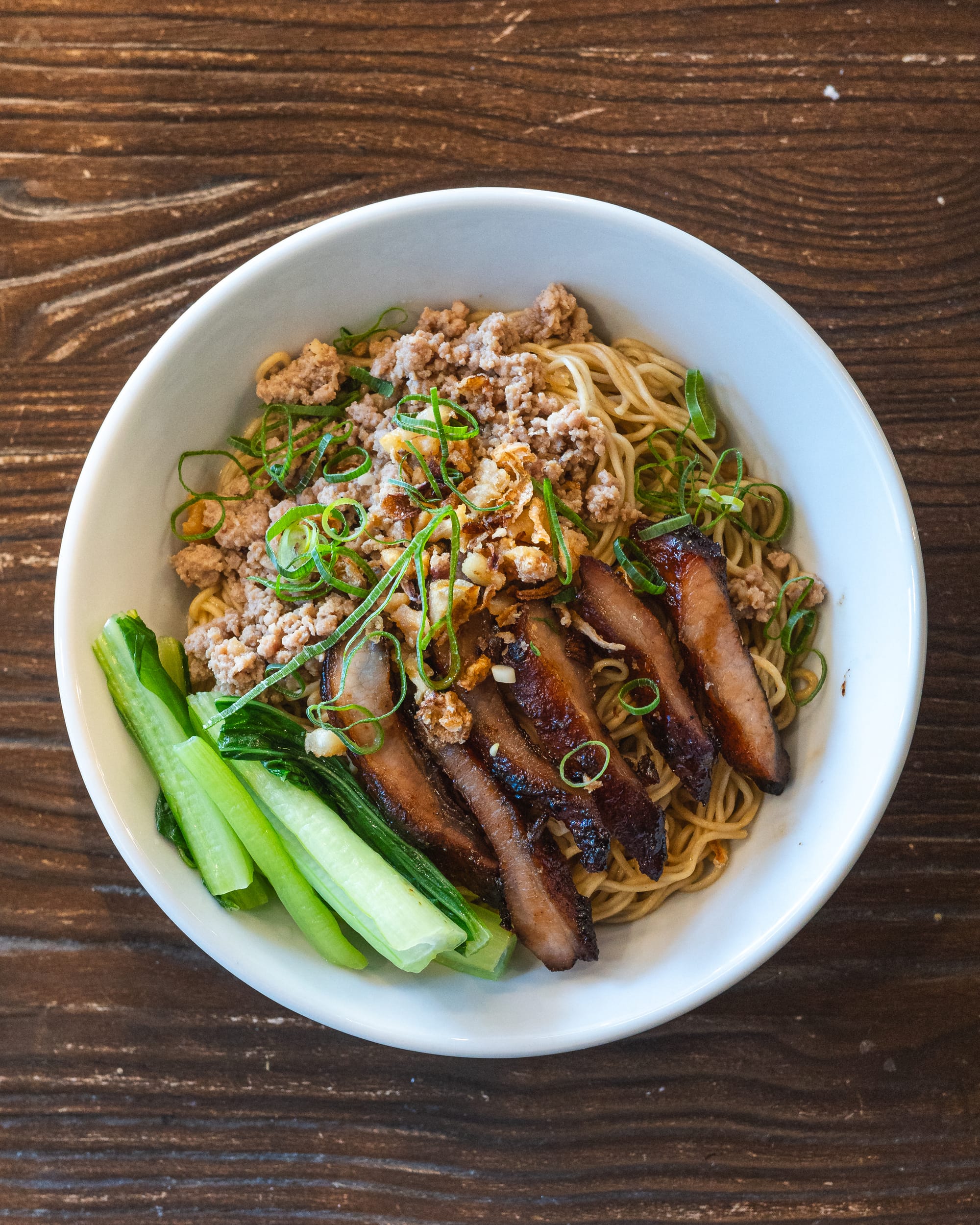 Top down shot of mince pork noodles with bok choy, BBQ pork, mince pork and noodles