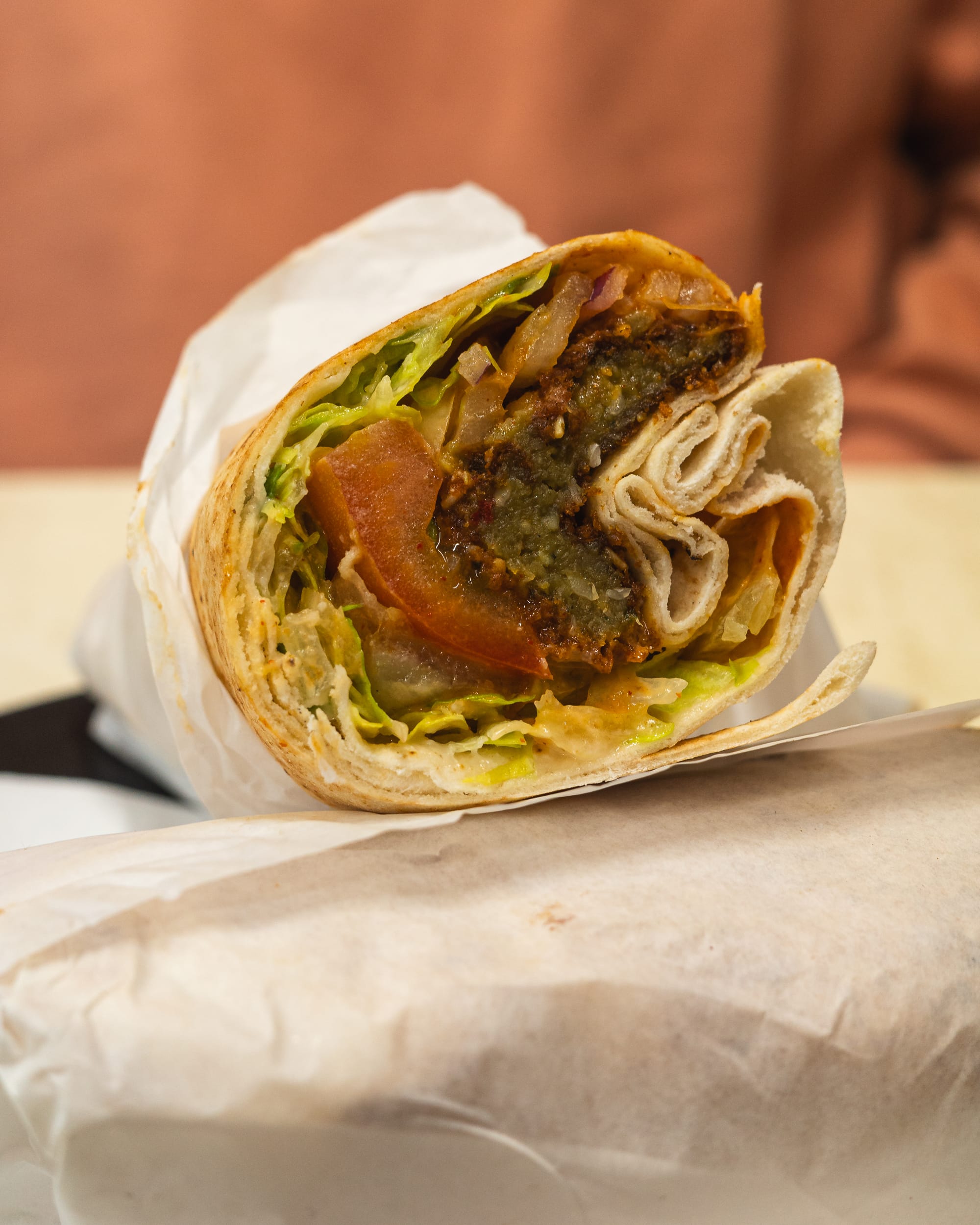 Close up of kebab with tomato, falafel and lettuce showing