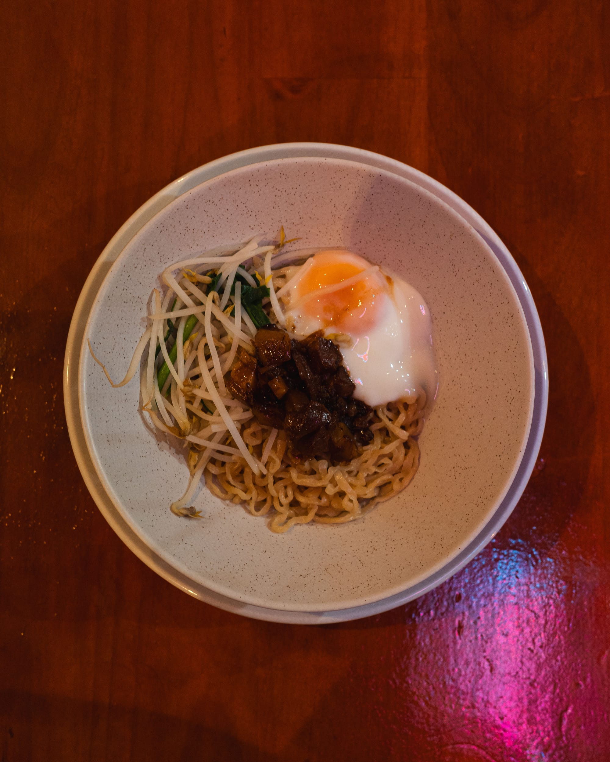 Top down shot of minced pork belly with noodles and a soft boiled egg