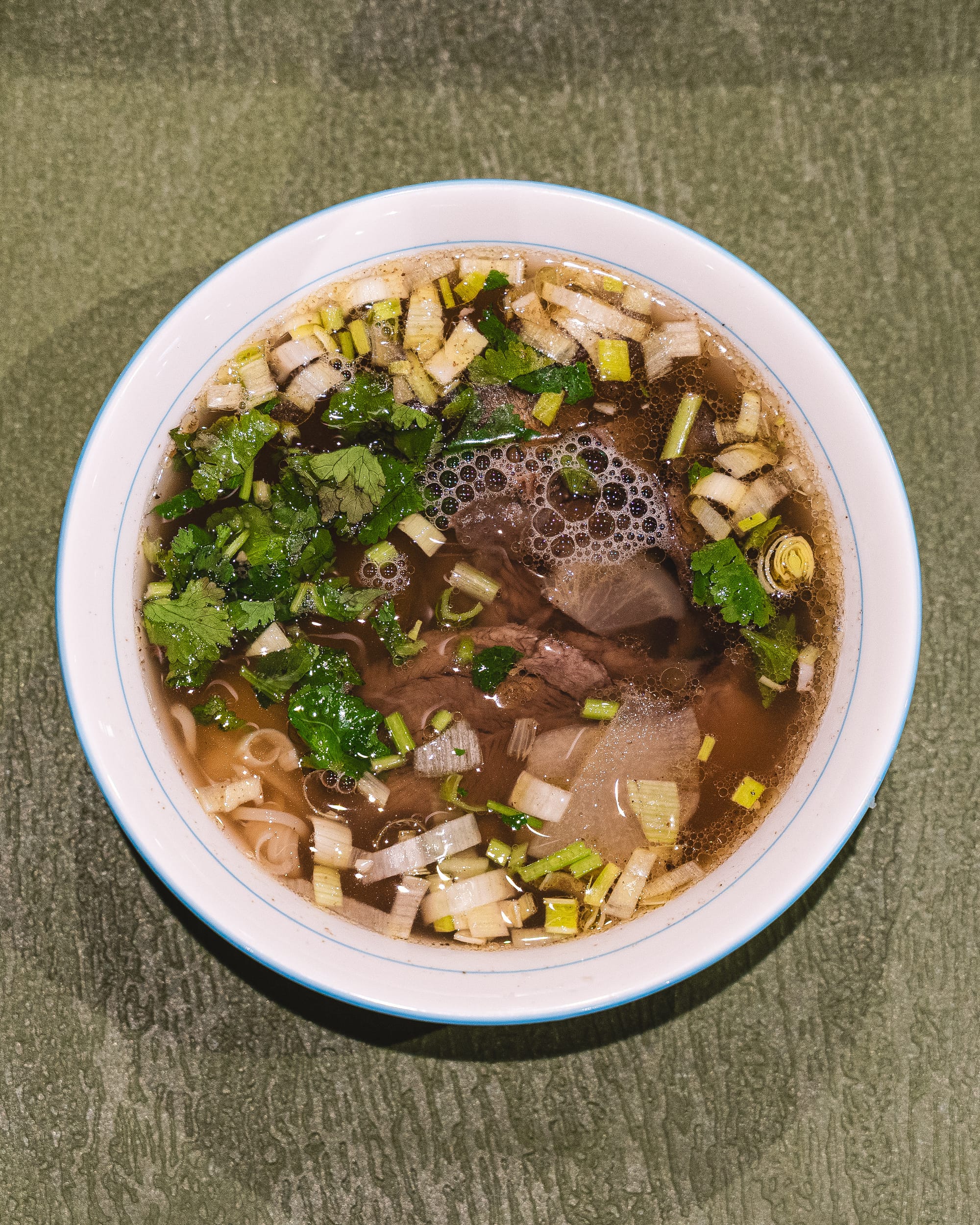 Top down bowl of noodles with coriander, onion and beef