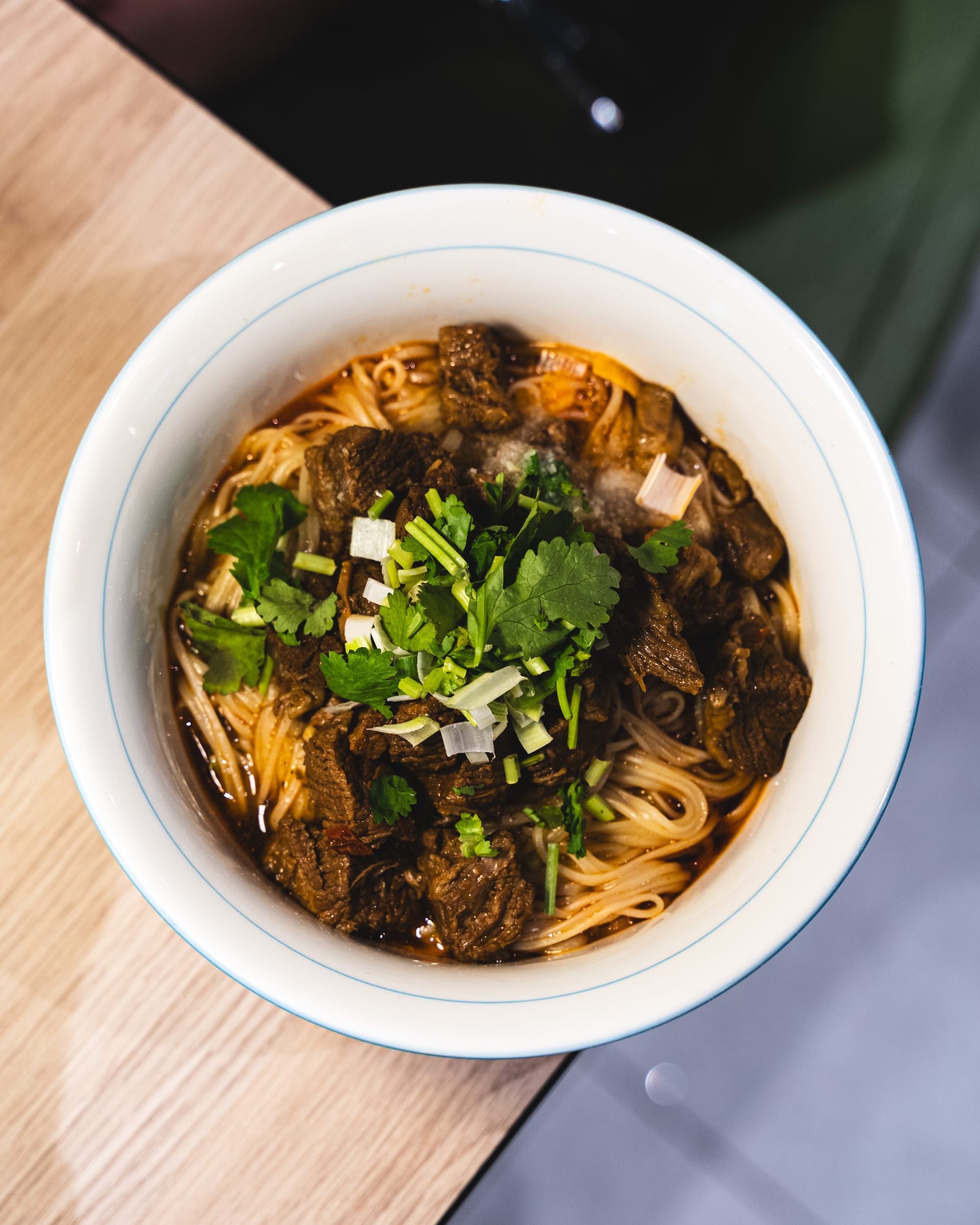 Top down shot of braised lamb noodles with coriander