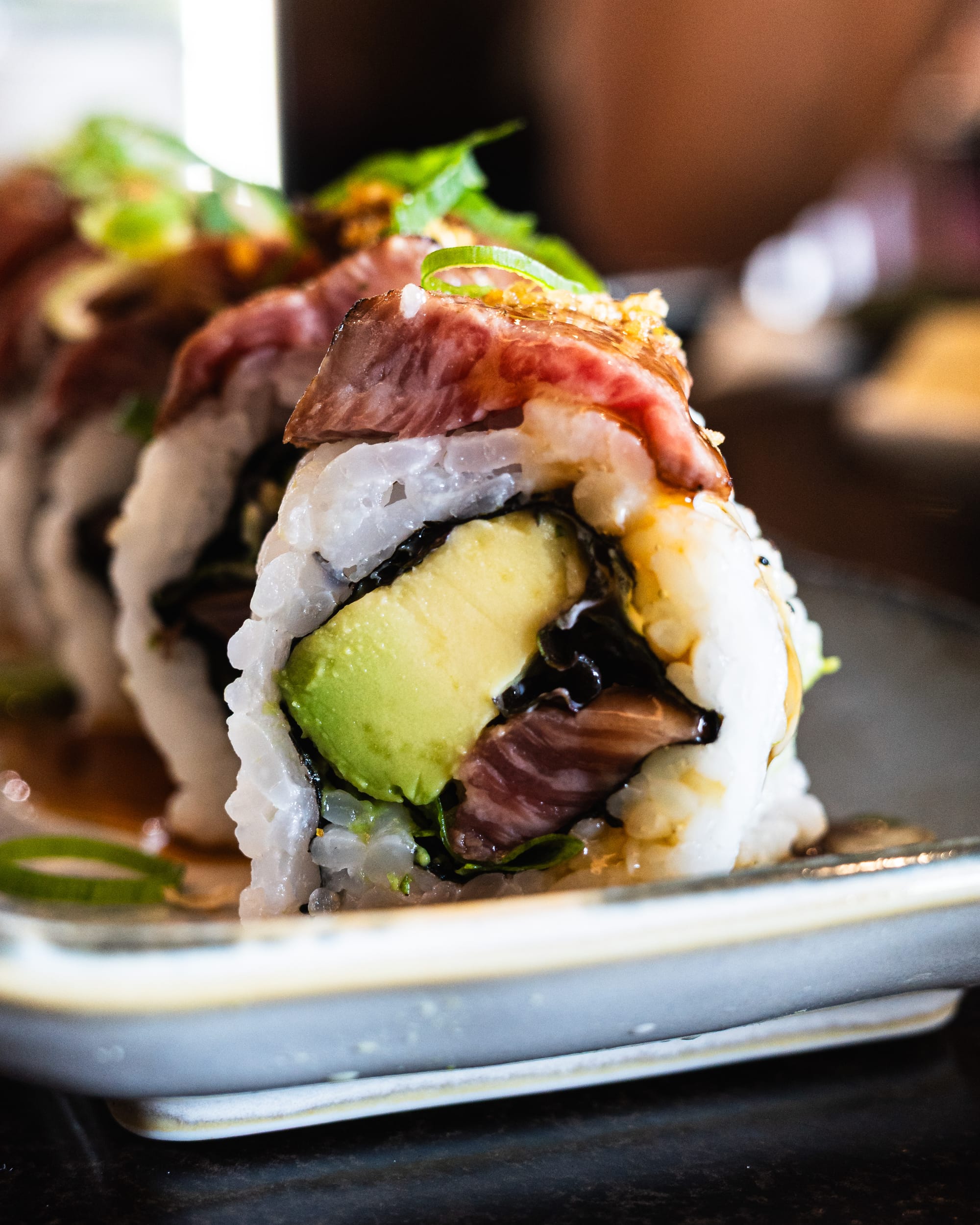 Close up shot of sushi roll with avocado and wagyu