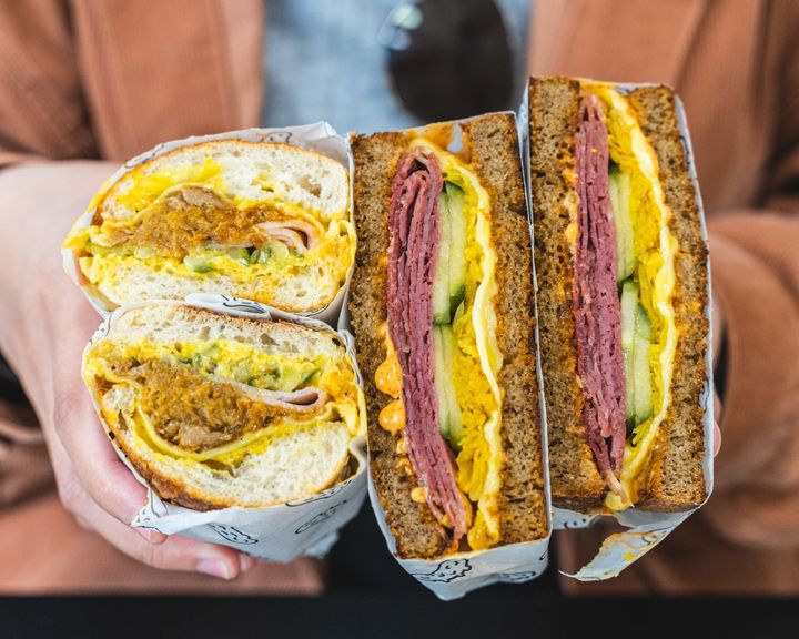 Hand holding two sandwiches