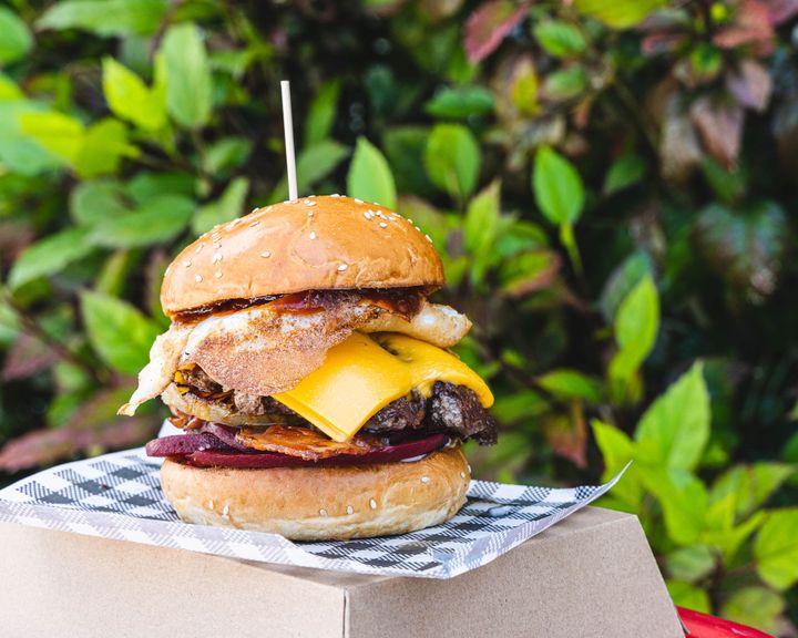 Close up of burger with egg, cheese and beef showing