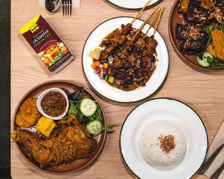 Top down shot of Indonesian fried chicken, chicken satay and beef ribs and rice