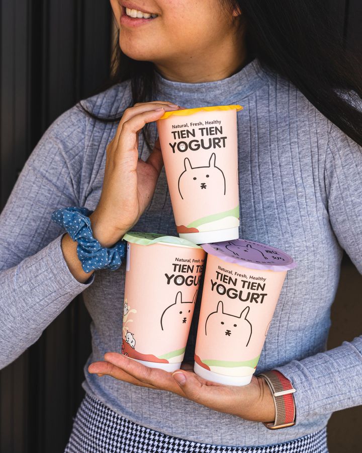 Female holding three drinks stacked on-top of each other