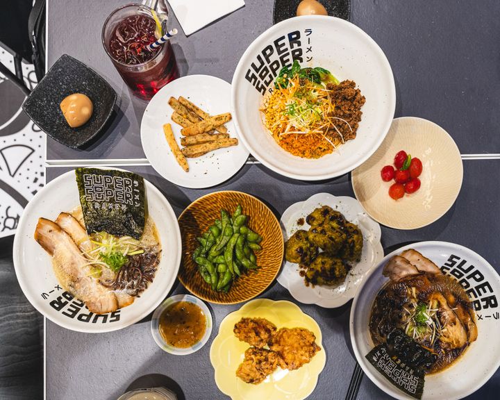 Overhead shot of ramen, edamame, karaage, chips, egg and more