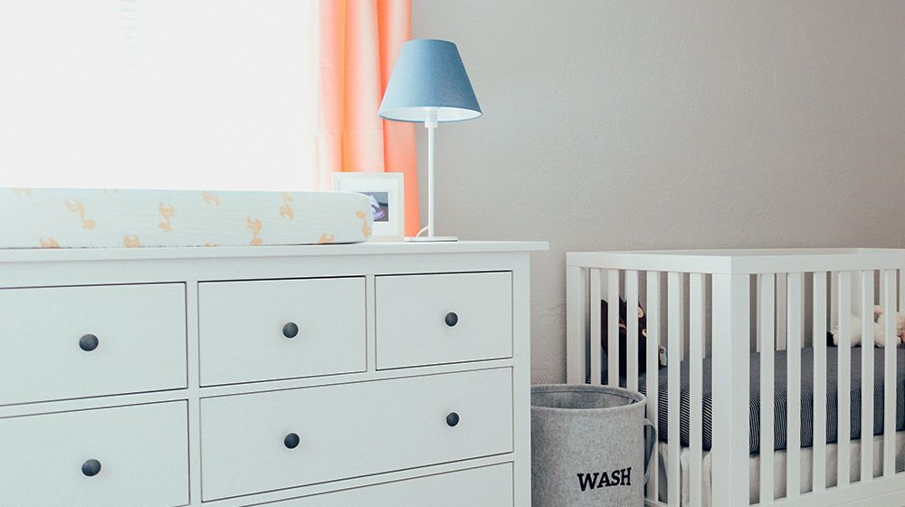 white dresser and crib in a simple nursery