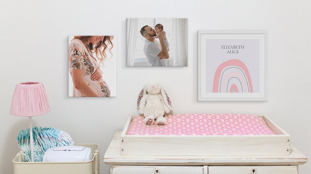 personalized photos and art on the wall above changing table in a nursery