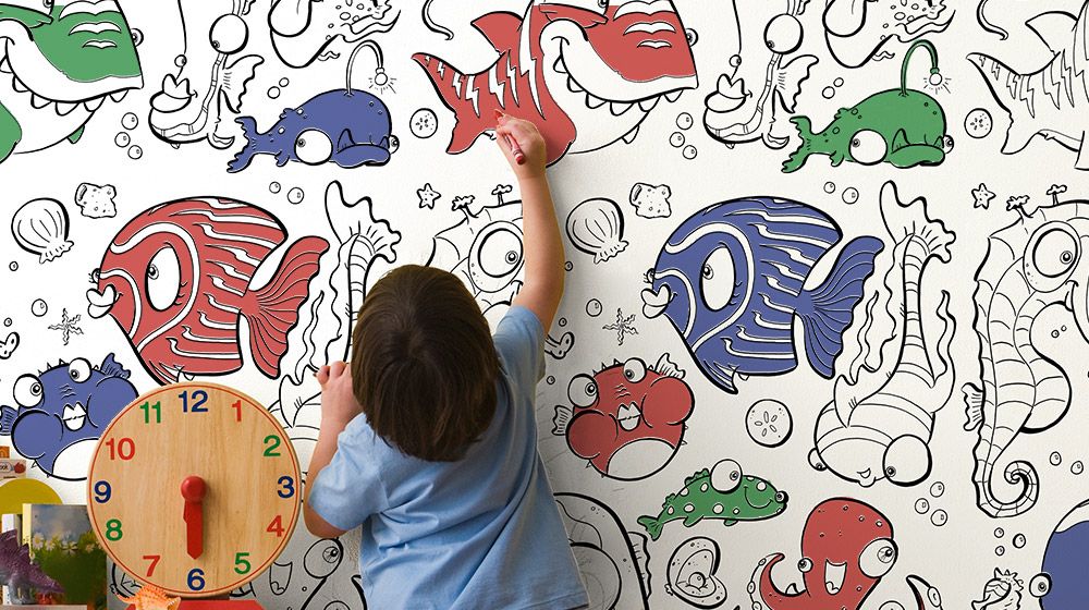 A child coloring a removable coloring wallpaper design