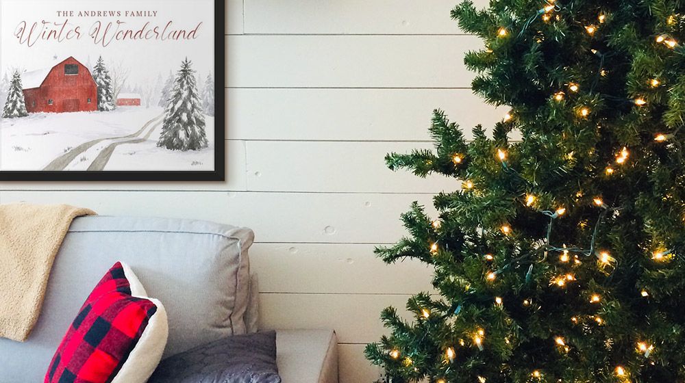 Holiday-themed, personalized word art hangs near a Christmas tree