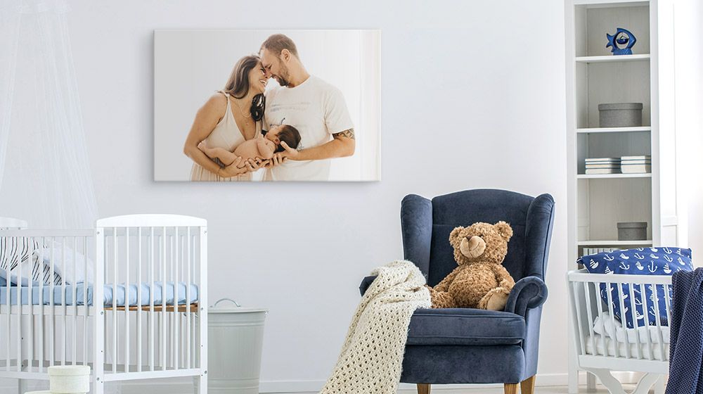 photo canvas print depicting parents with their newborn on a nursery wall