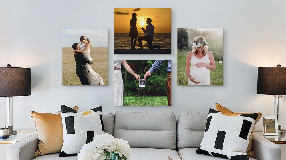 gallery wall of canvases featuring engagement, wedding, and maternity photos above couch