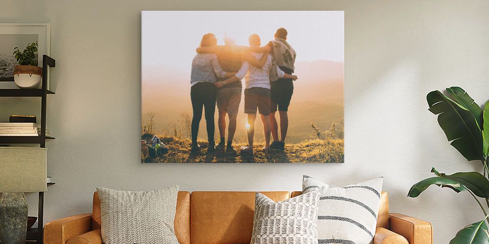 large canvas print depicting family photo at sunset over a leather couch