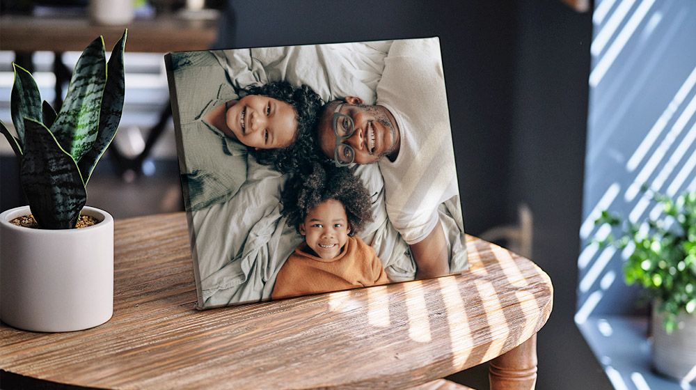 8x10 Tabletop Canvas of a dad and his two children leaning on a living room end table.
