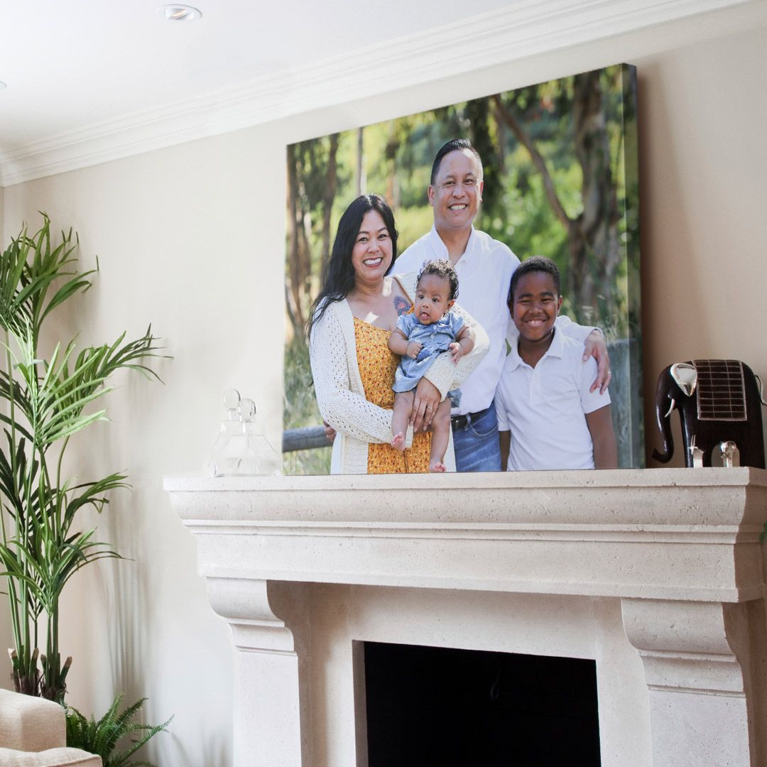 posed family photo printed on a large canvas print sits upon a stone mantle