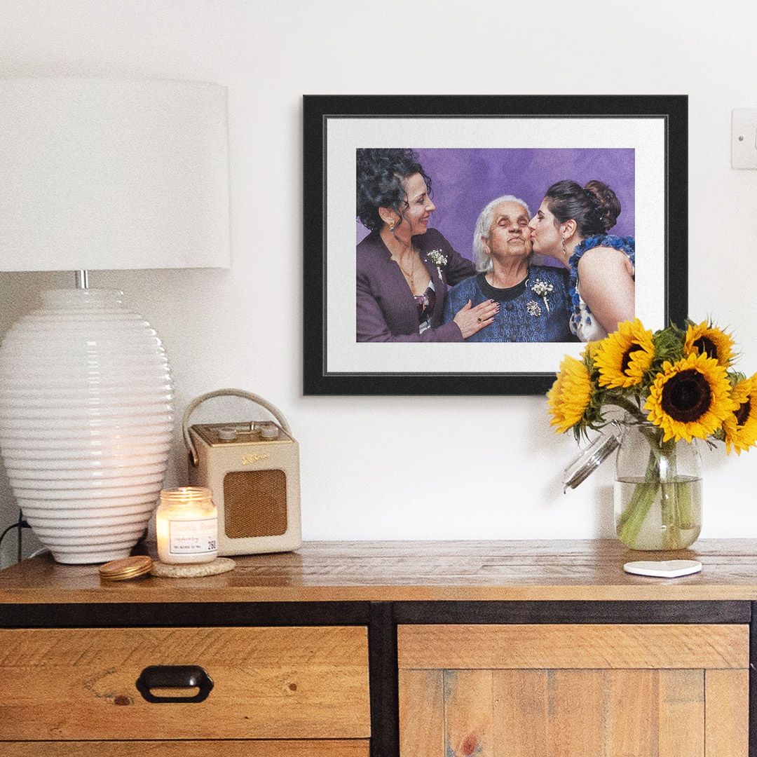 a framed photo of grandma and her two daughters above a dresser