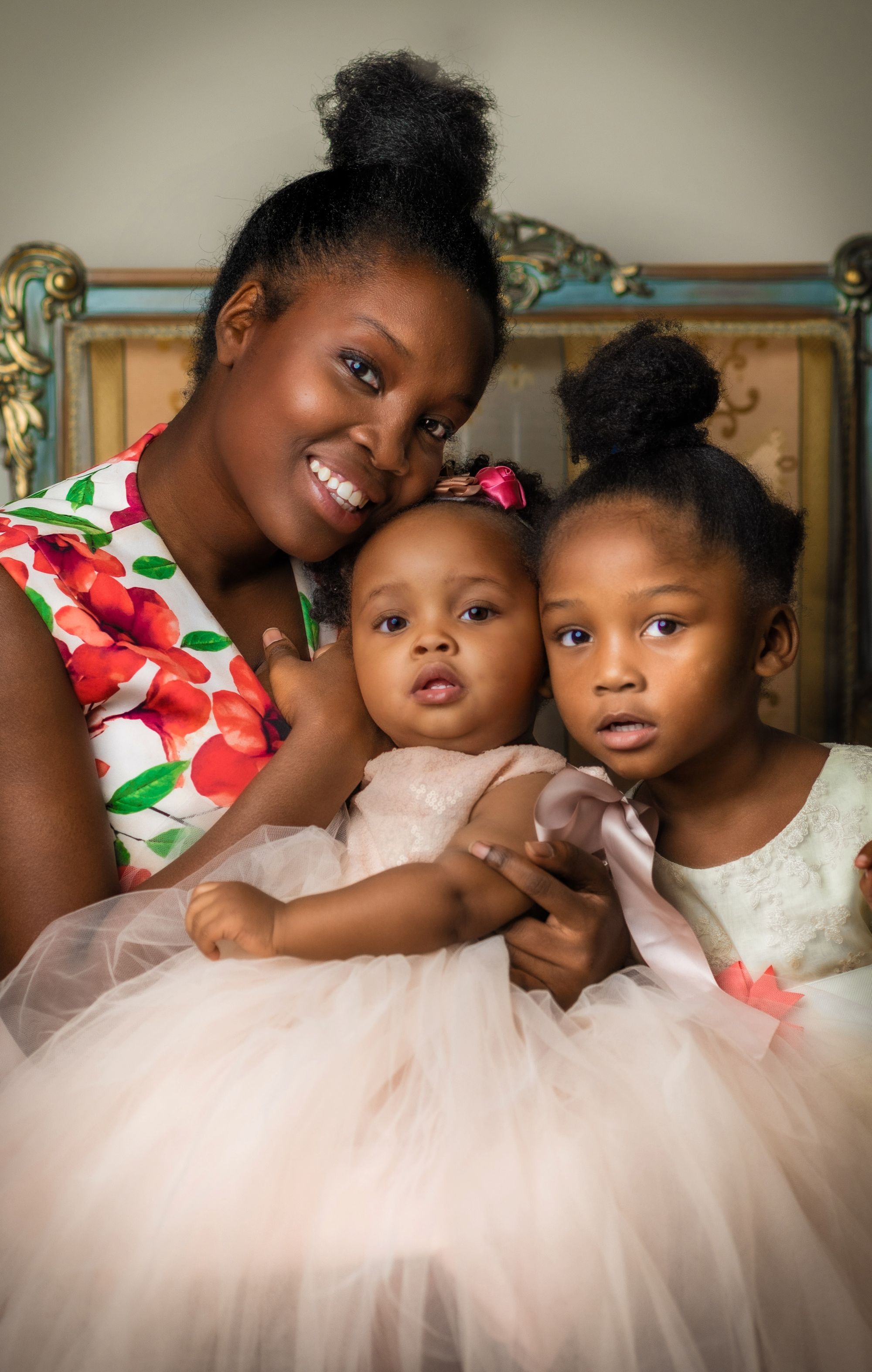 Mom posing for an at home photoshoot with her two adorable daughters