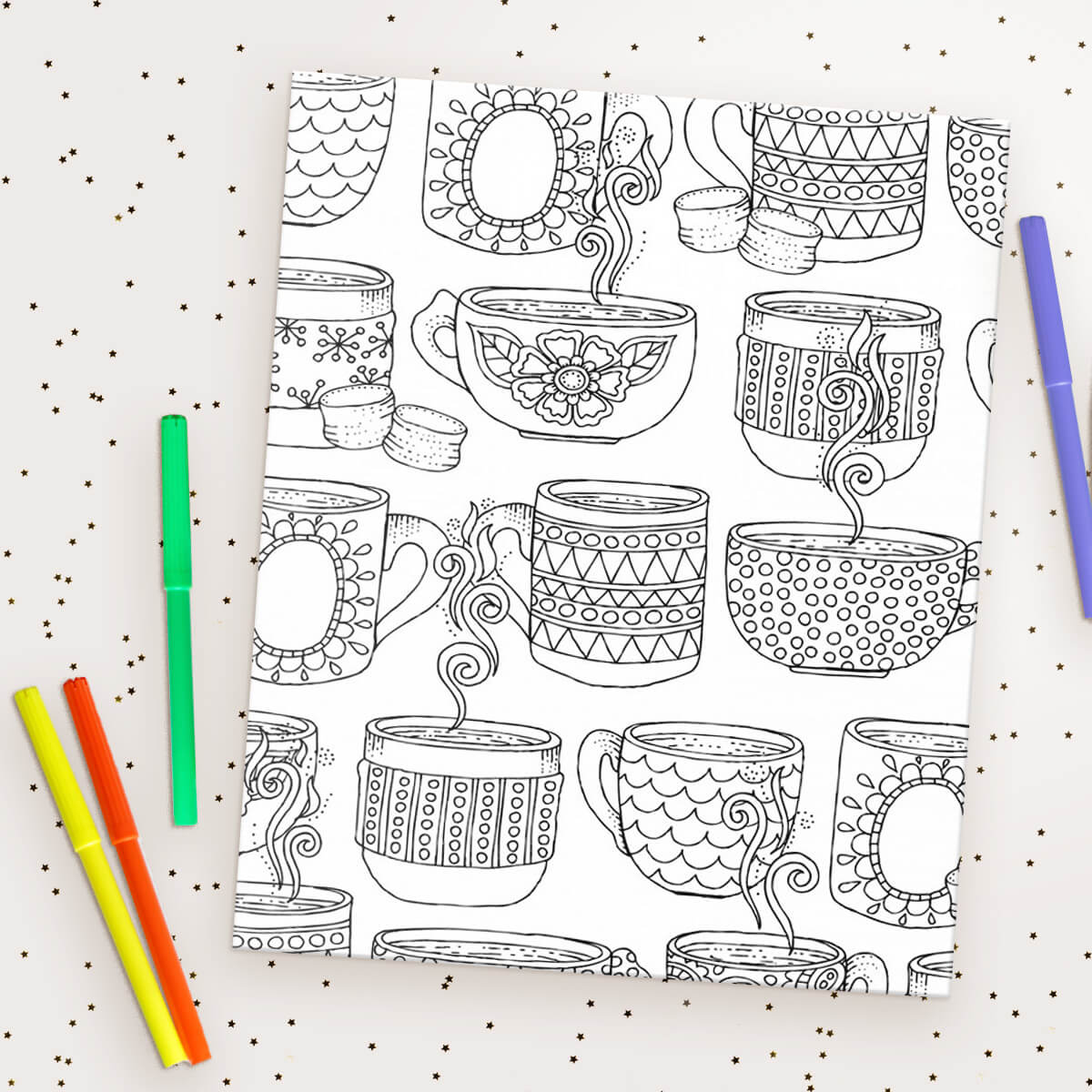 A holiday print Coloring Canvas lays on a table, all set to color with the markers around it.