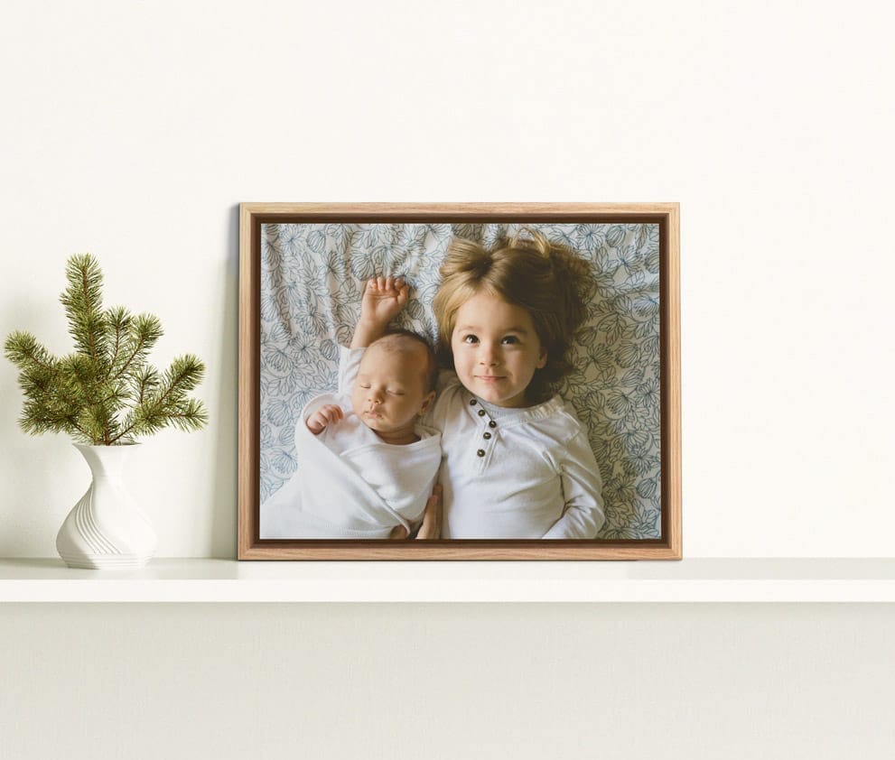 A wooden framed canvas of daughter and her baby-brother