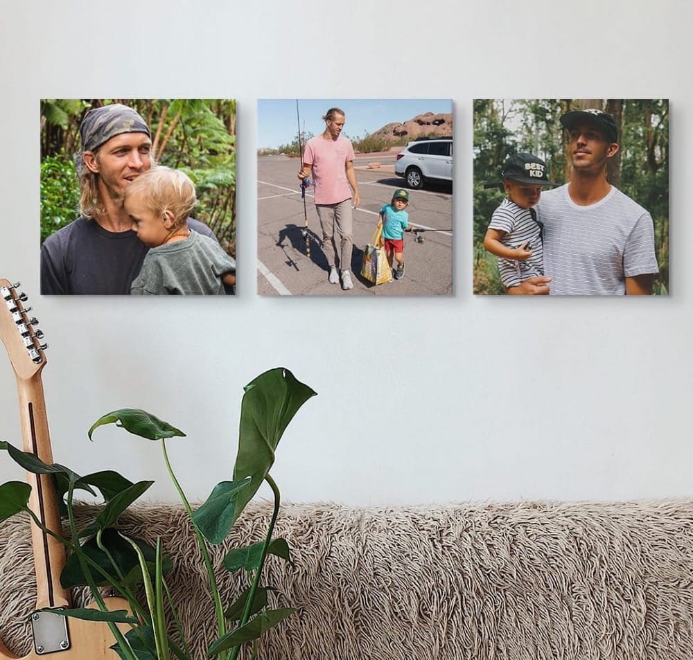 A guitar on a couch with a backdrop of multiple canvas prints of a father and his son.