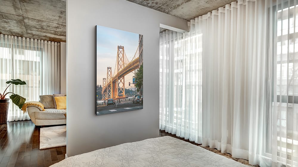 canvas print of city bridge placed near window reflecting natural light in bright room