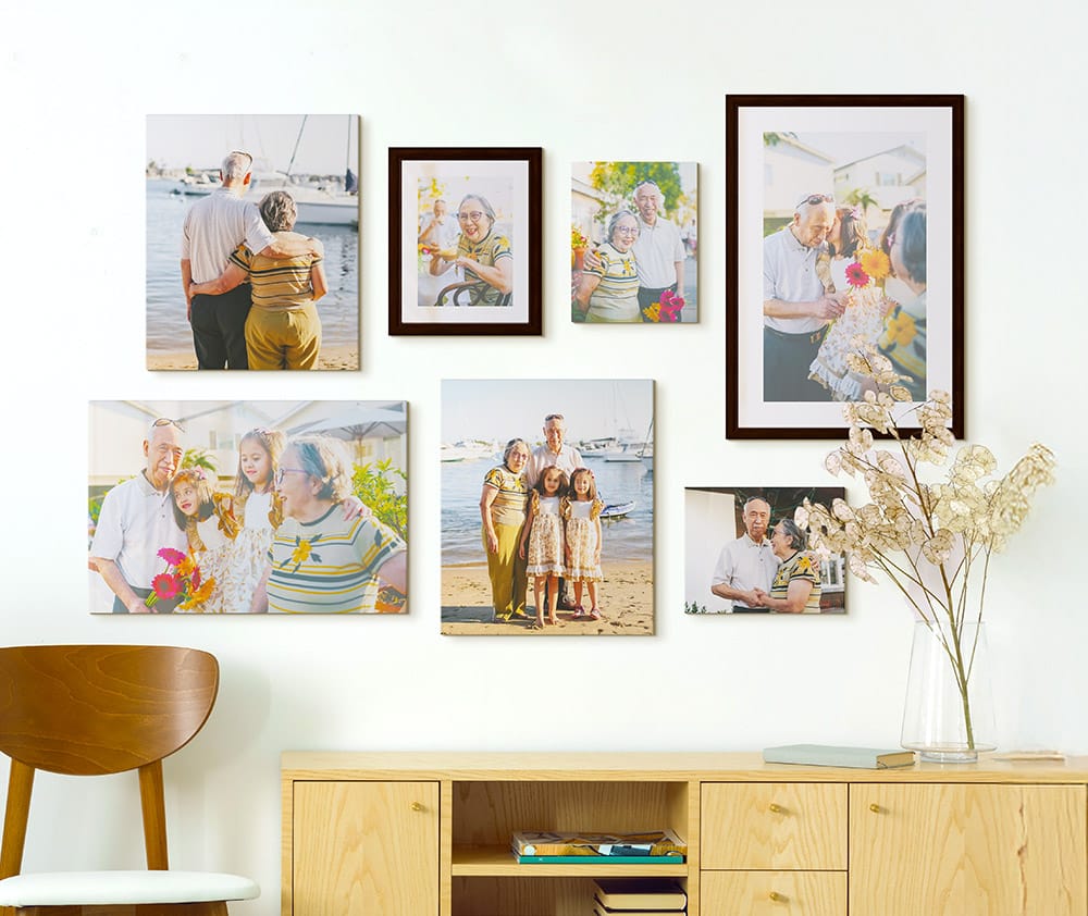 framed paper prints and canvas prints arranged above console table in home