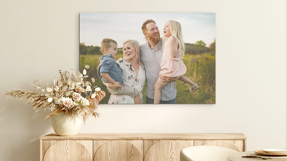A wide family photo canvas centered above a long wooden sideboard, complementing the proportions of the furniture.