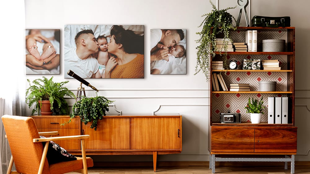 Three family photo canvas prints arranged above a midcentury sideboard in a living room.