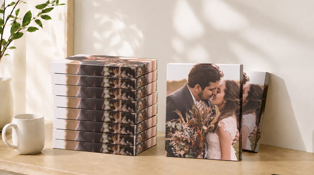Ten wedding photo canvas prints with mirror edges showing a couple kissing, with eight stacked and two standing upright.
