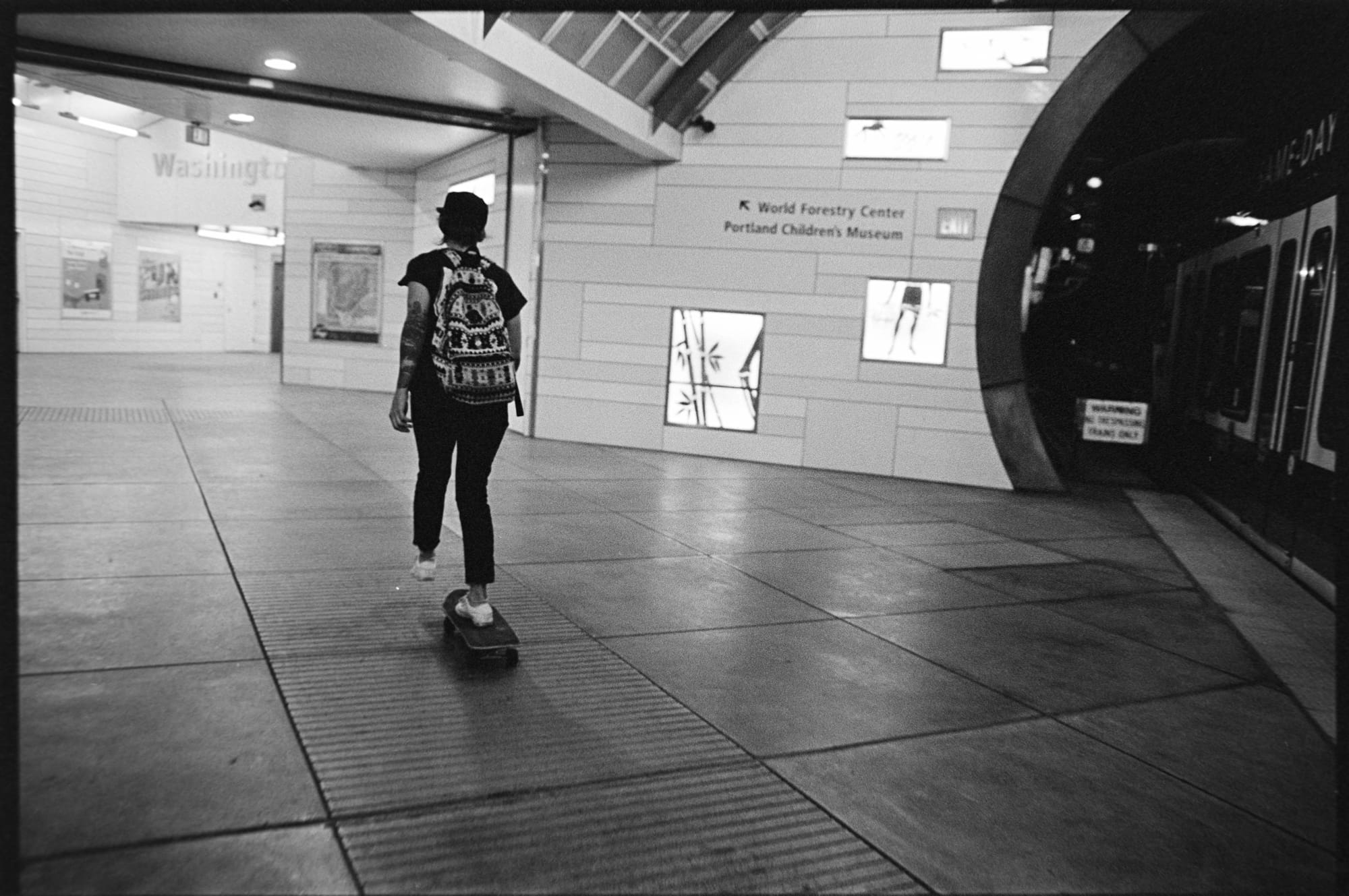 A woman skating through a train station.