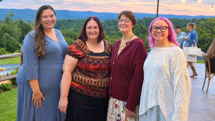 four Fayette Chamber employees with sunset and mountains in background