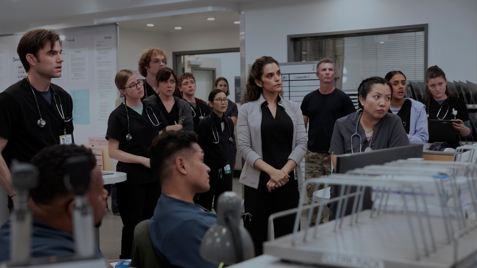 A group shot of multiple doctors and nurses in the Pitt where only Javadi vaguely matches Al-Hashimi in styling.