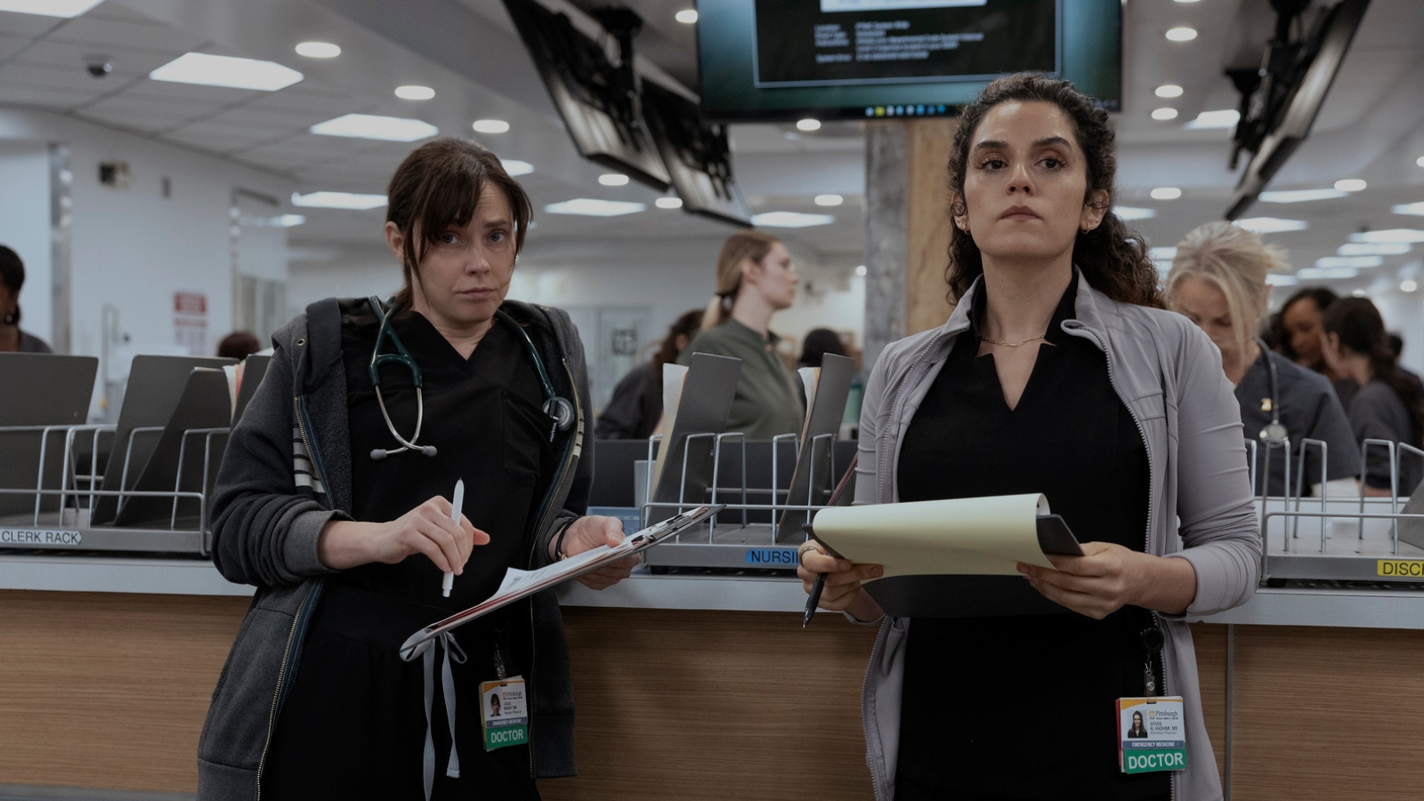 Dr McKay in a grey striped hoodie over her scrubs in contrast to Al-Hashimi in her light jacket.