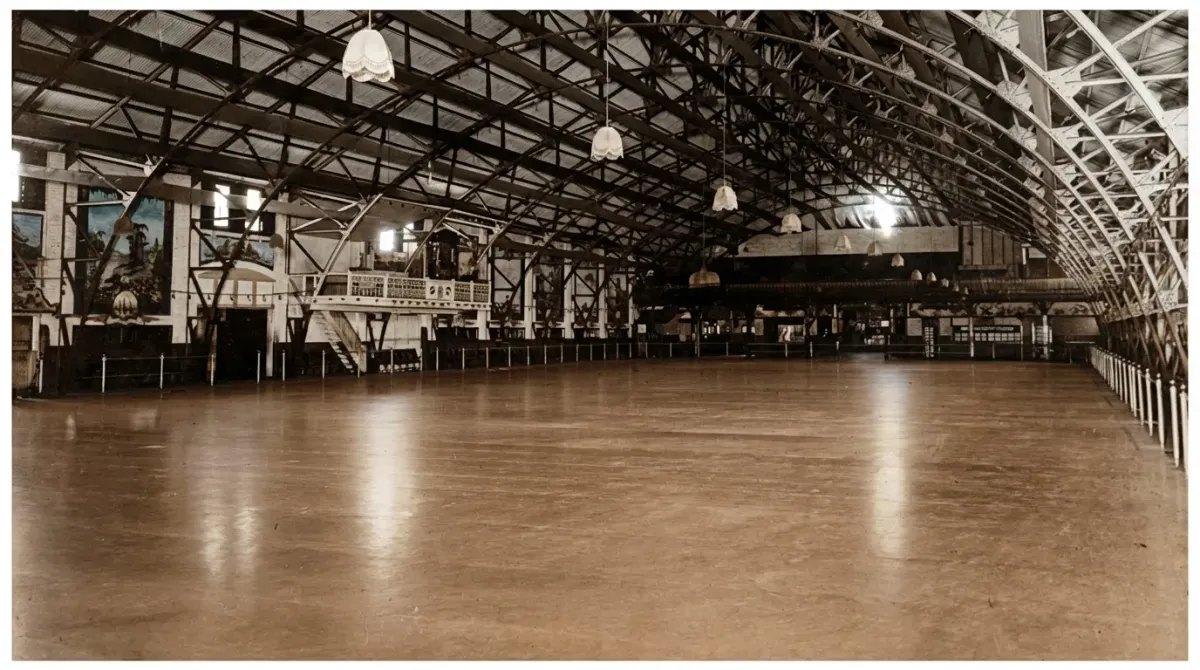 Historic indoor roller skating rink in Sydney with a large timber floor, arched steel roof and hanging lights, photographed i