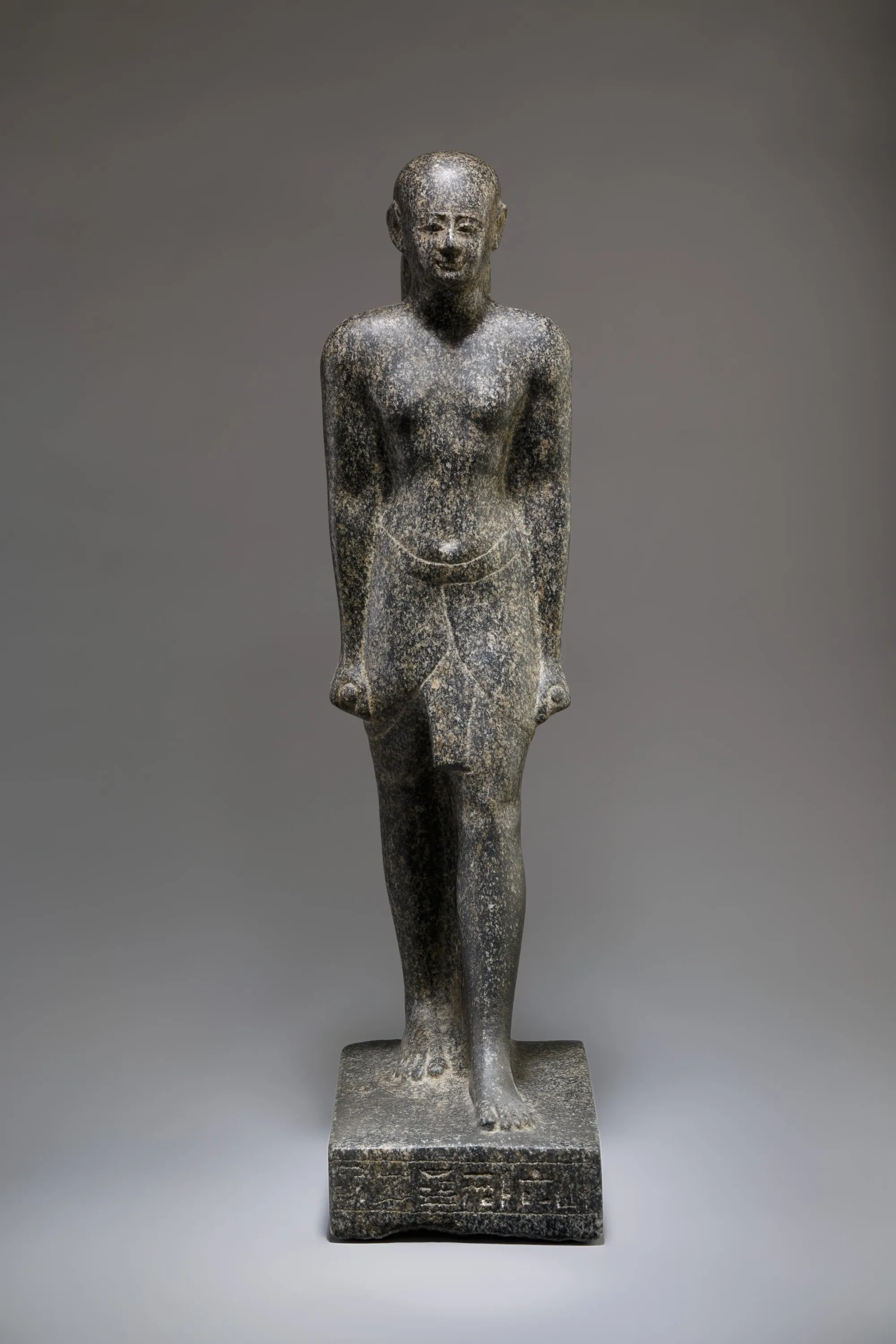 Complete standing statue of the Egyptian priest Harnefer with an inscribed base.