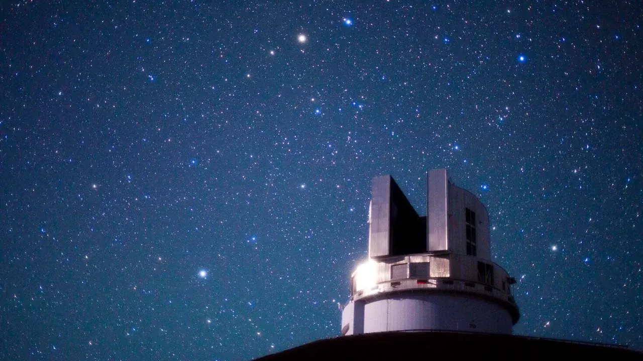 The Subaru Telescope enclosure on Maunakea beneath a dense field of stars.