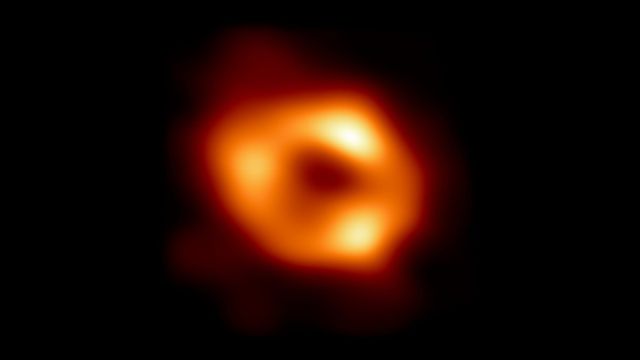 EHT image of Sagittarius A*: a bright orange ring around a dim central region.